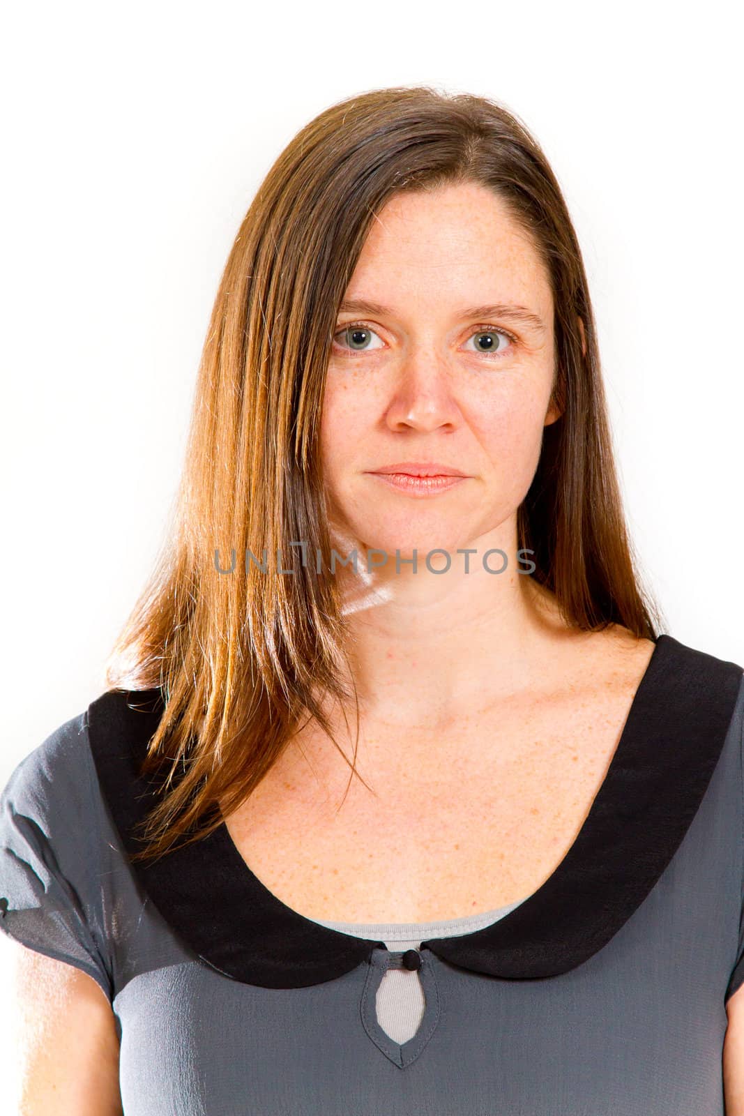 A pretty woman poses for a portrait in the studio against an isolated white background while wearing black and grey and looking happy.