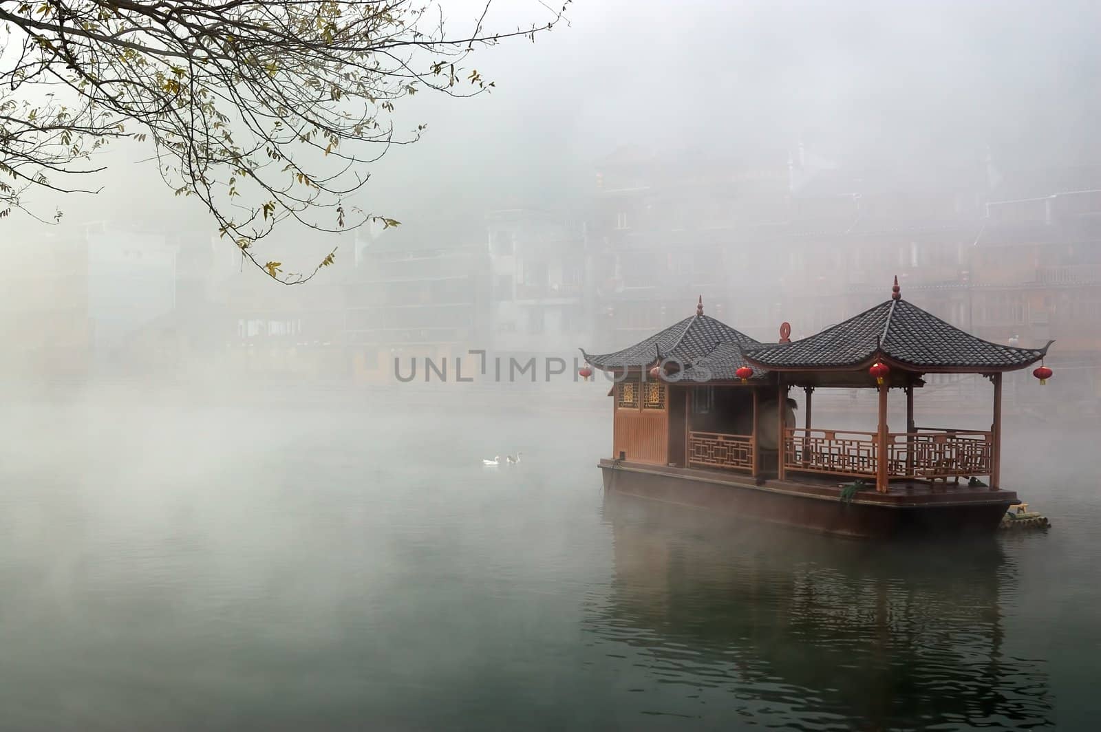 China landscape of boat on foggy river with traditional building background in Hunan province