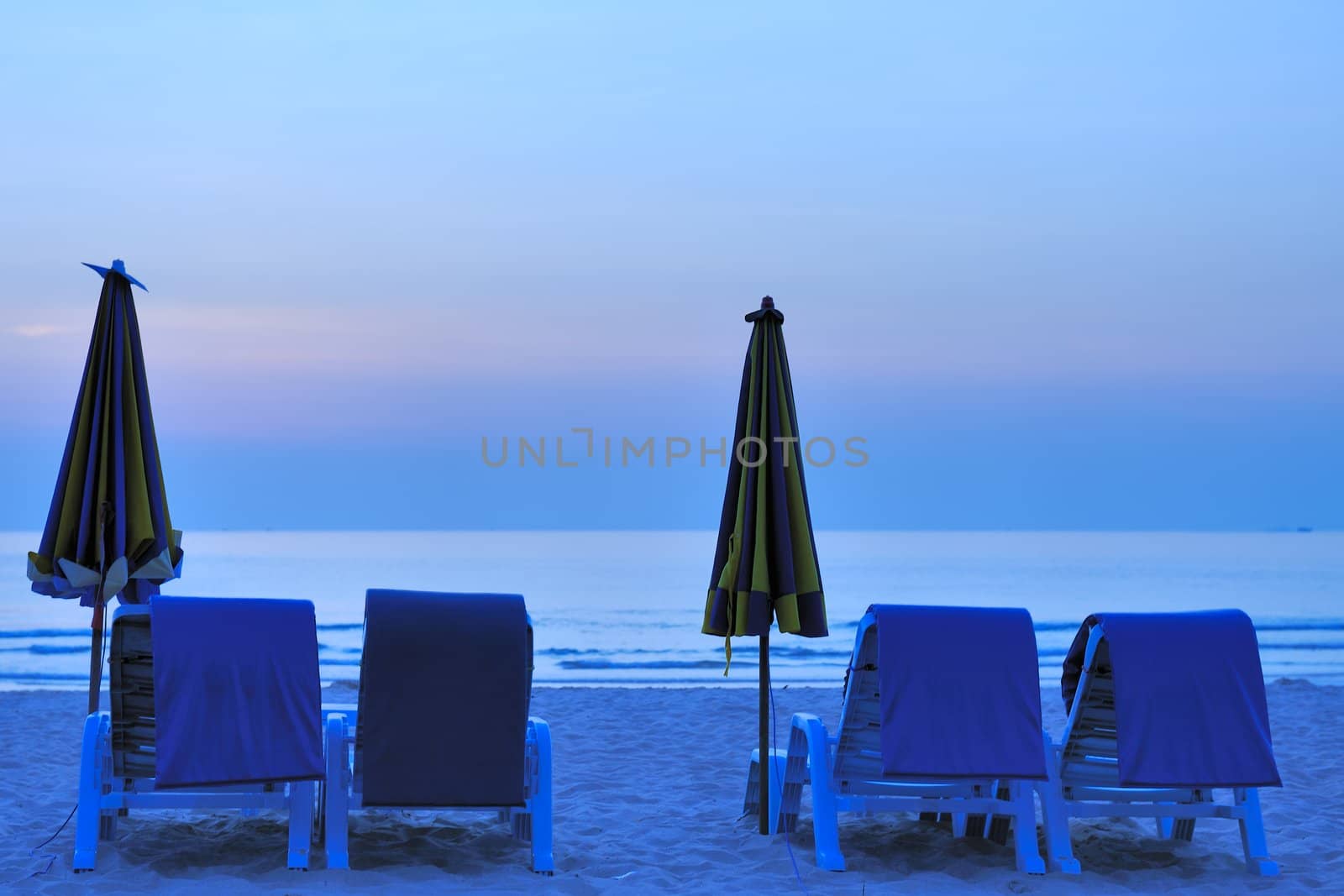 Beach landscape with two folded umbrella in Phuket Island, Thailand