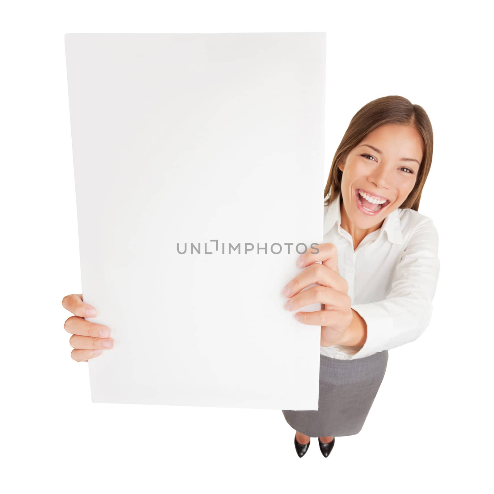 Businesswoman with blank sign excited. Fun high angle perspective of an attractive young happy cheerful businesswoman holding up a blank sign for your attention with copyspace for your advert or text isolated on white