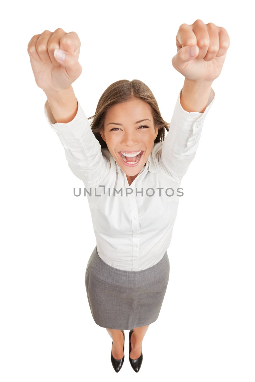 Ecstatic happy woman cheering and winning. Humorous high angle perspective of a beautiful winner woman laughing and celebrating as she raises her hands in the air in jubilation, isolated on white.