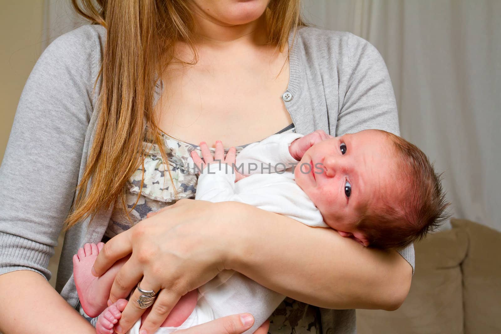 A mother holds her newborn baby boy in her arms.