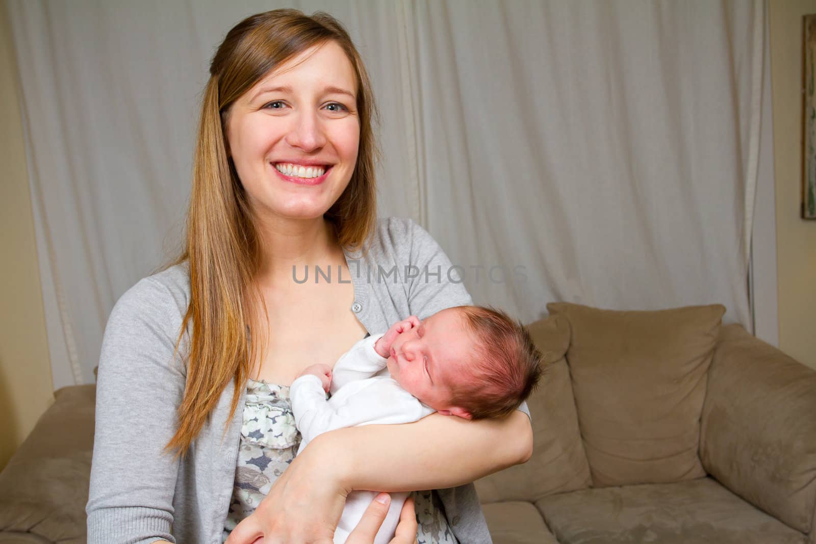 A mother holds her newborn baby boy in her arms.
