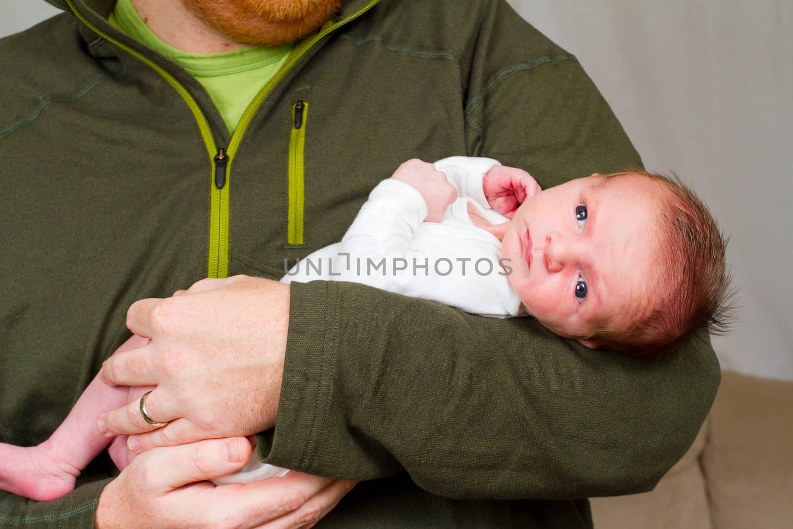 A father holds his newborn baby son in his arms.