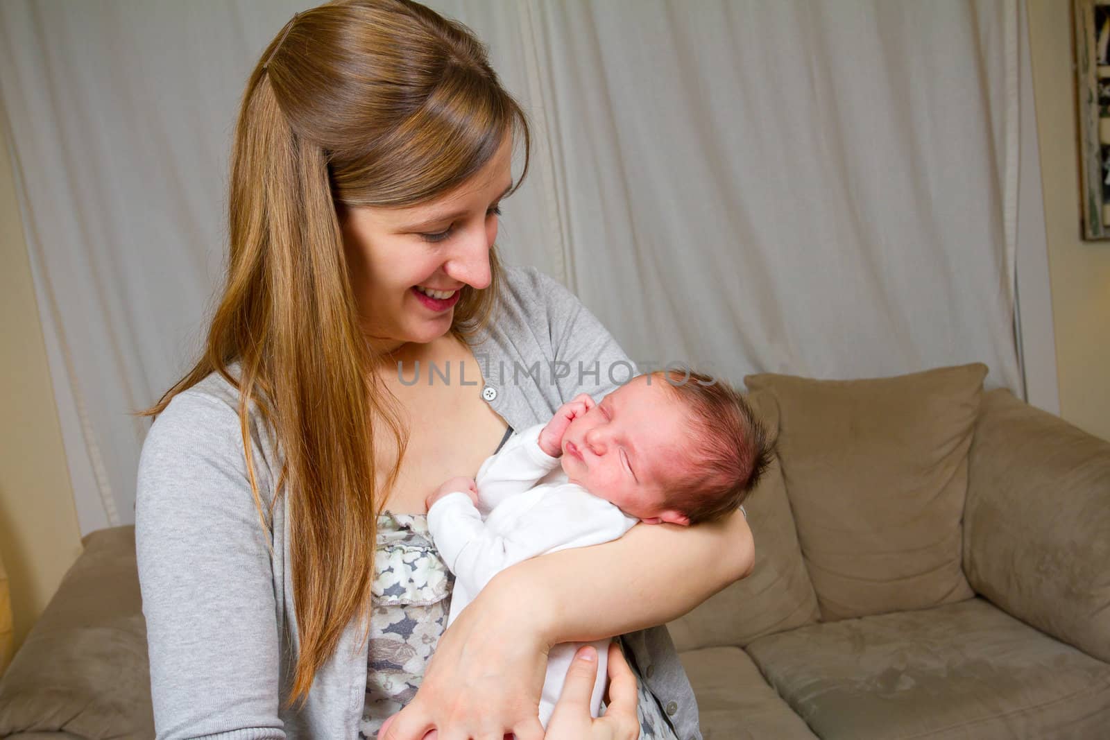 A mother holds her newborn baby son in his arms.