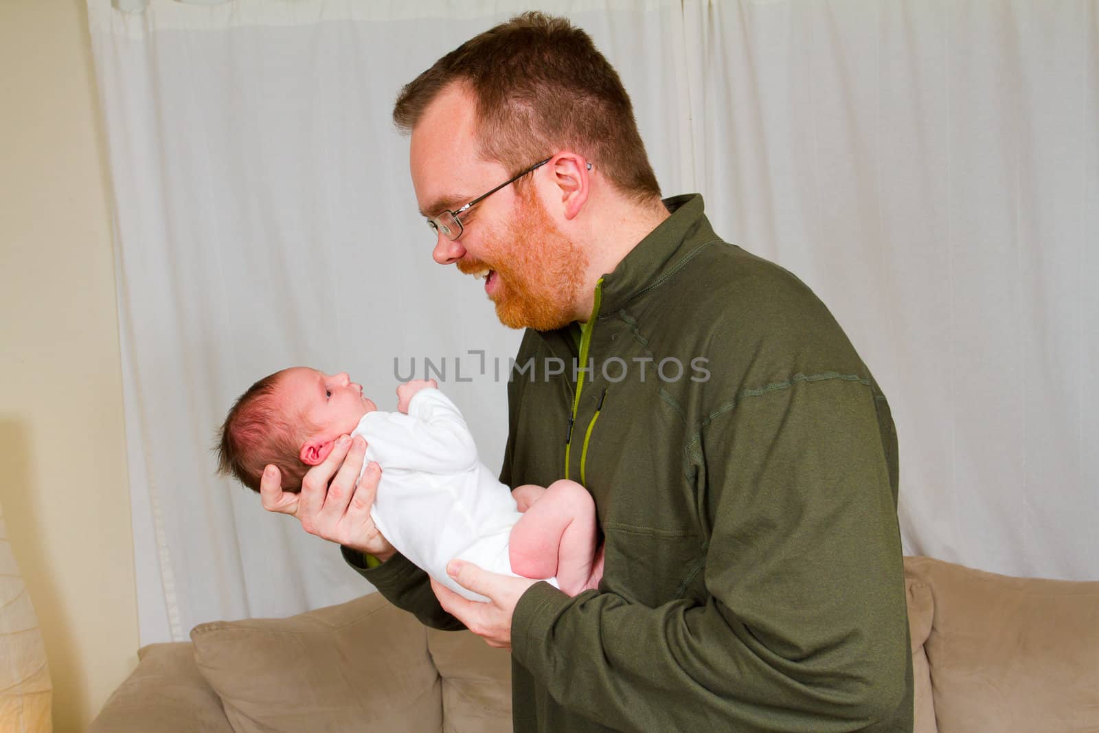 A father holds his newborn baby son in his arms.