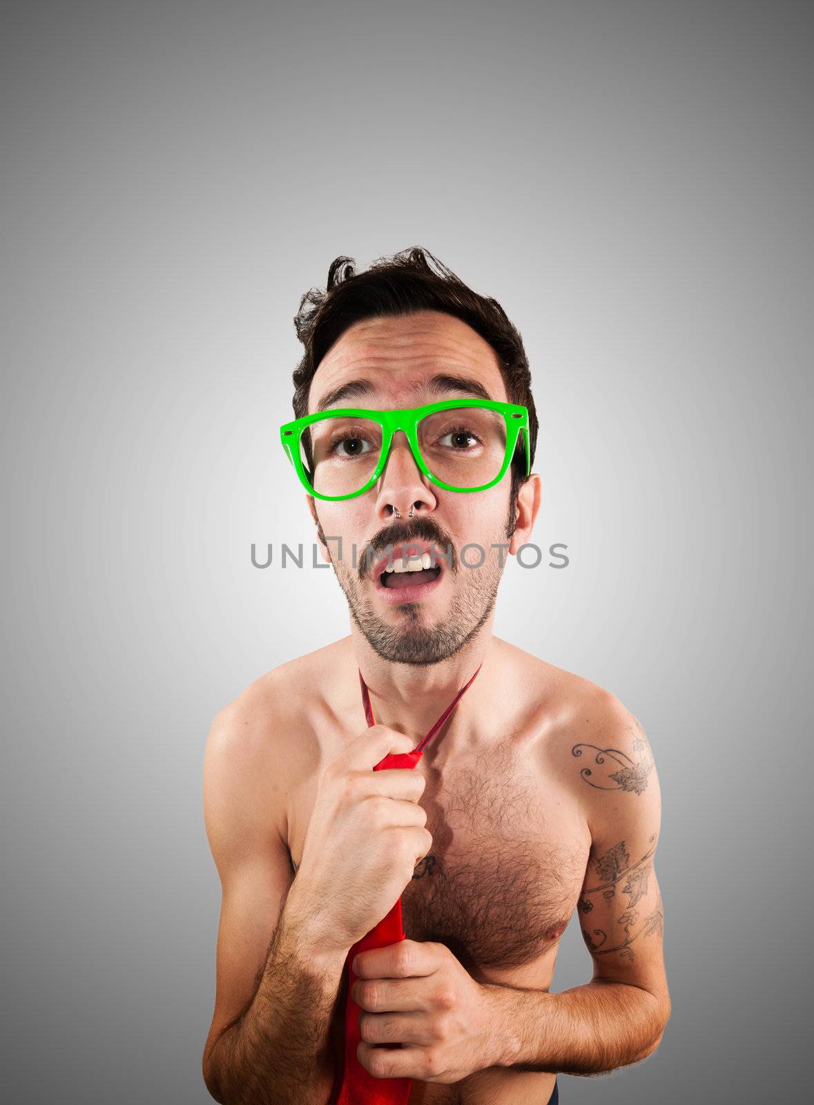 naked man wearing a red tie on gray background