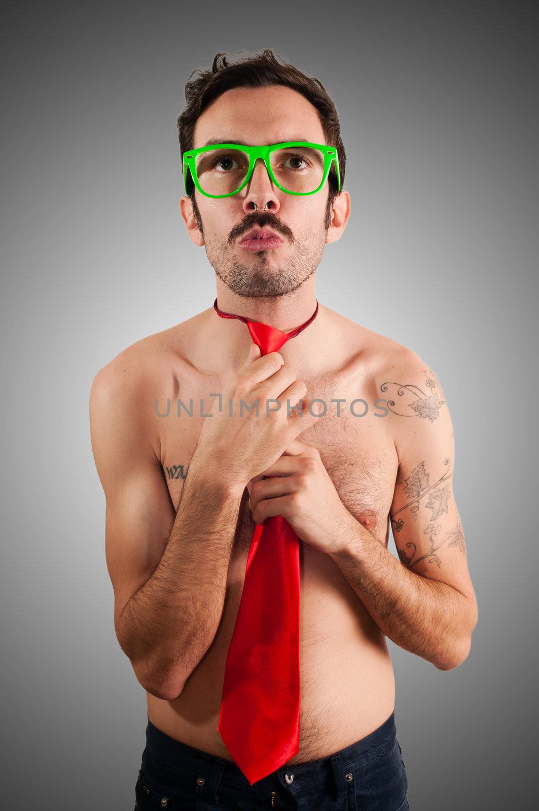 naked man wearing a red tie on gray background