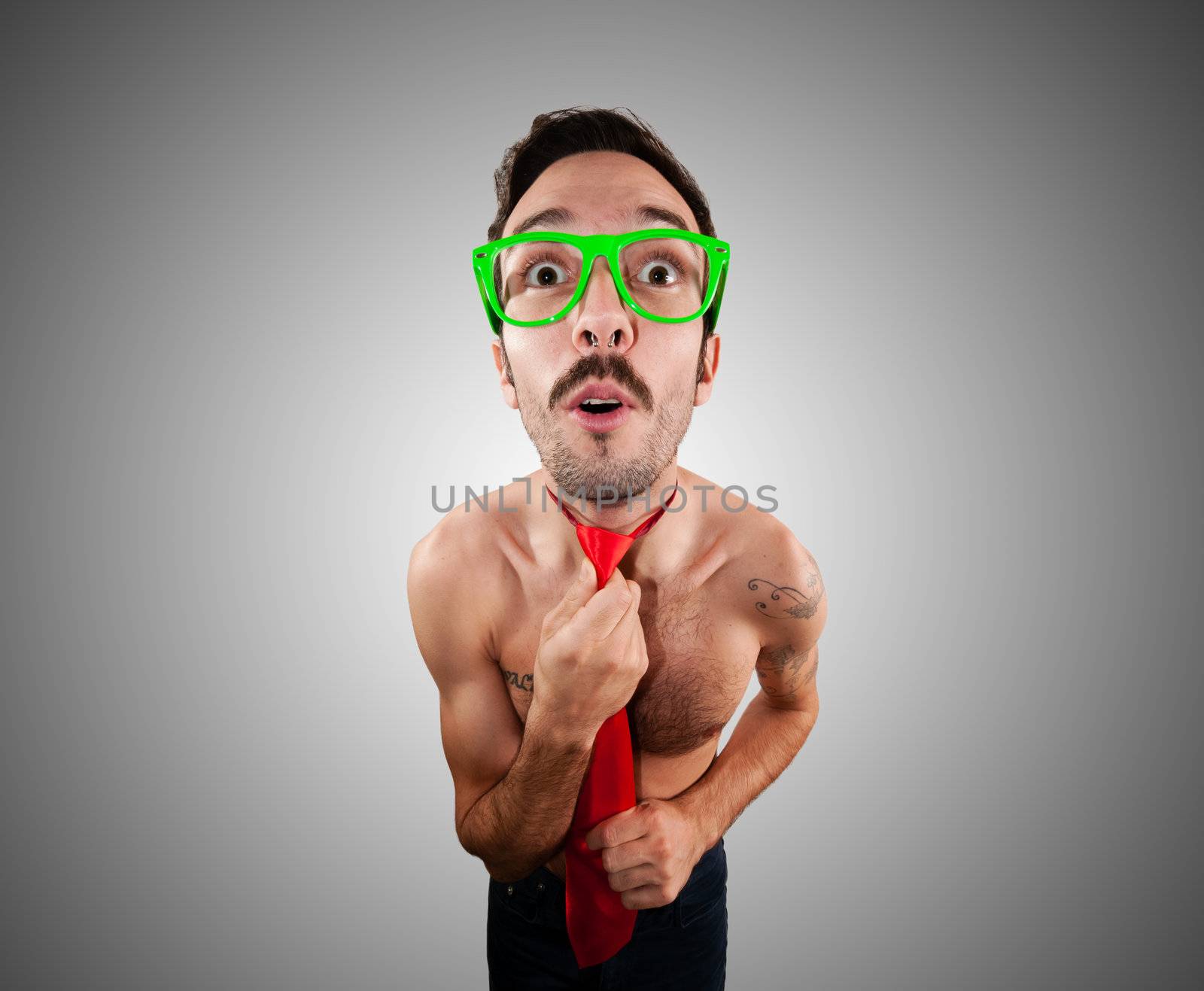 naked man wearing a red tie on gray background