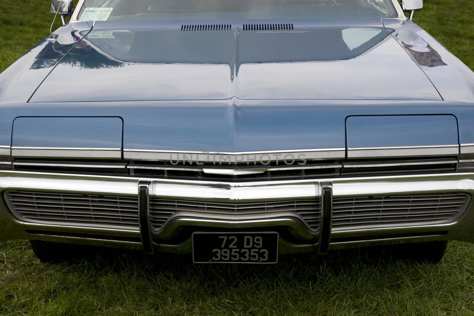 the hood of a classic American blue car with an altered number plate
