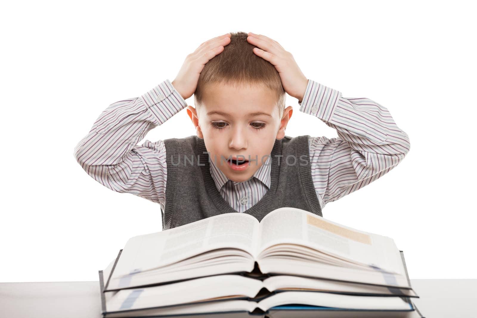 Amazed or surprised child boy reading education books at desk
