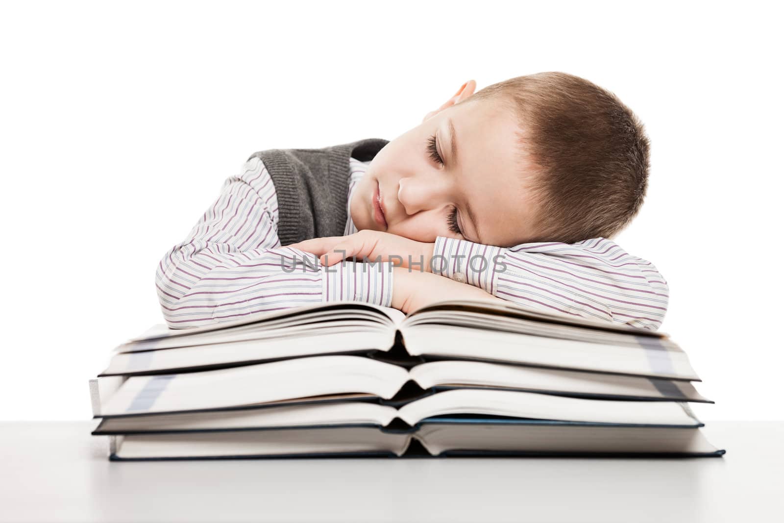 Tired child boy sleeping on education reading books at school desk
