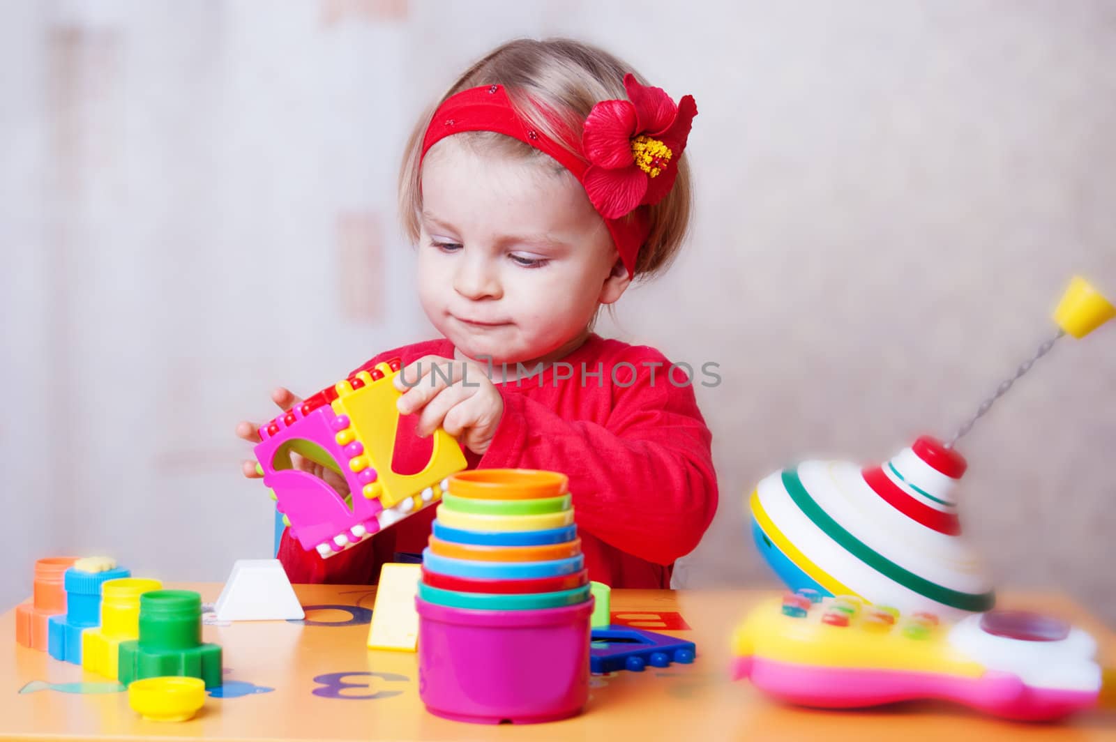 Interested baby girl playing sorter in nursery