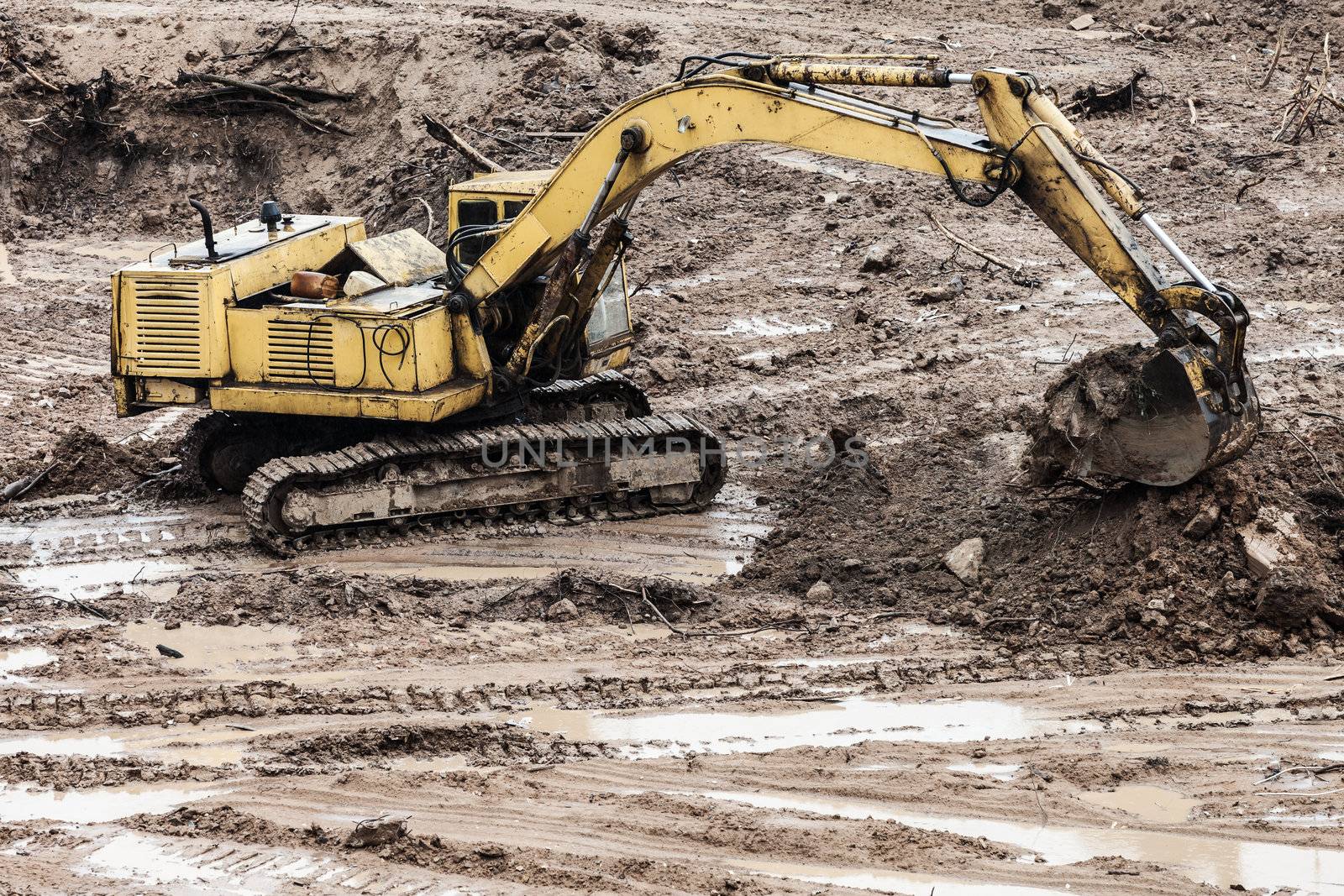 Old rusty earth digging excavator machine working at building construction site