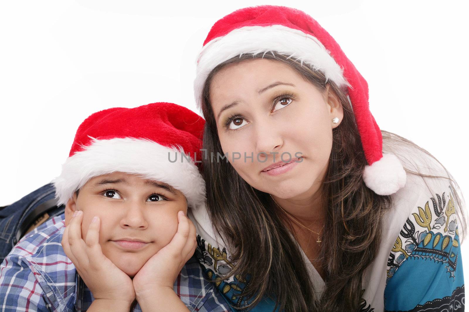 Mother and son in Santa hats smiling and looking up by dacasdo