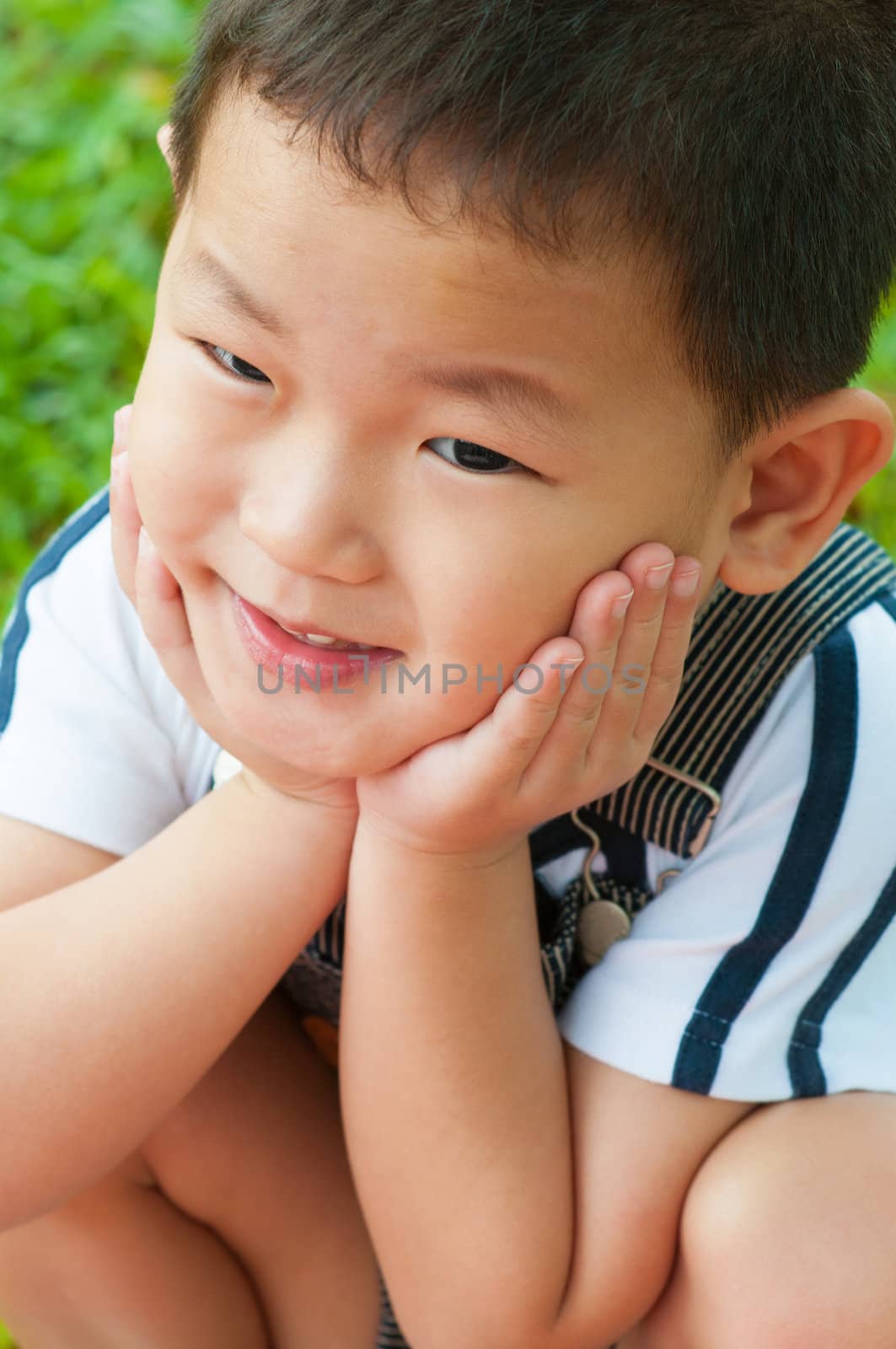 Close-up shot of a young Asian boy with smile on his face.