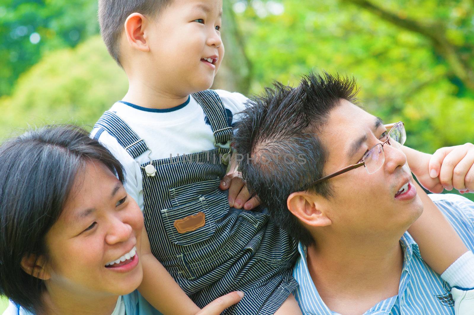 Happy Asian family having fun outdoor green park