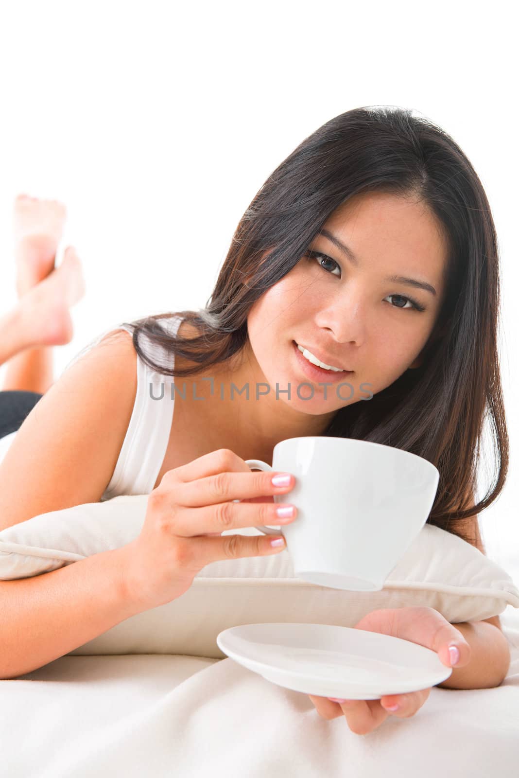 Relaxed woman drinking a coffee on her bed at home
