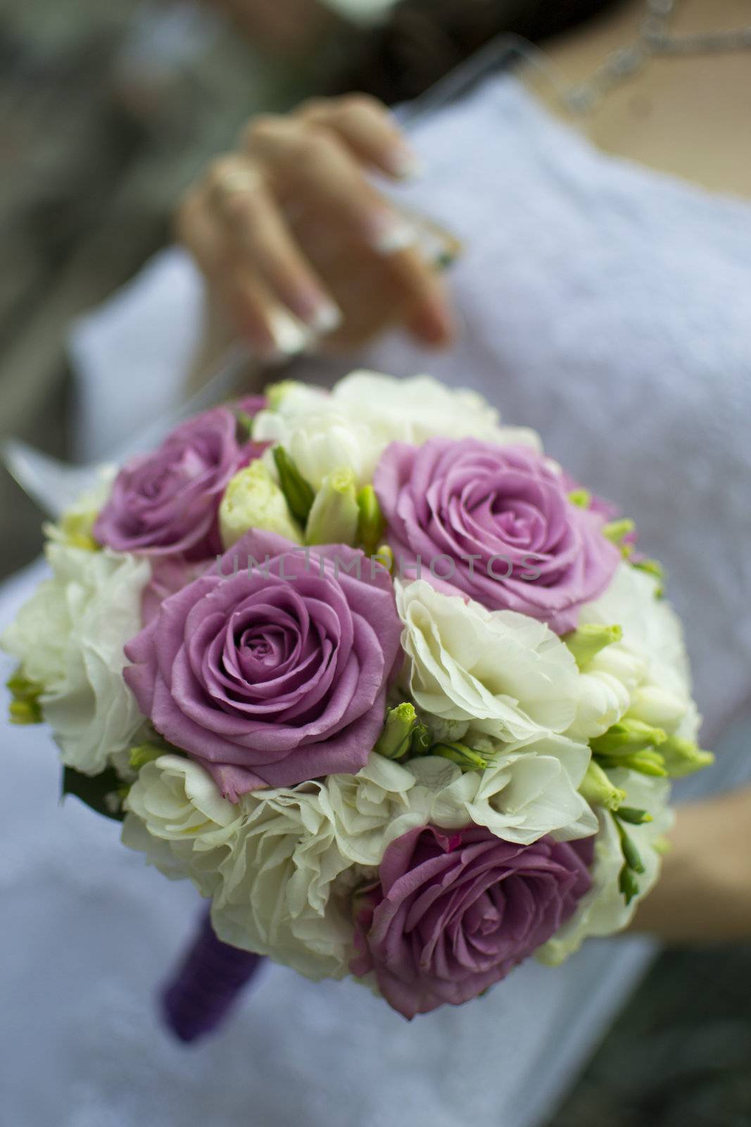 An elegant hand-tied bouquet of flowers in the hand of a bride. by only4denn