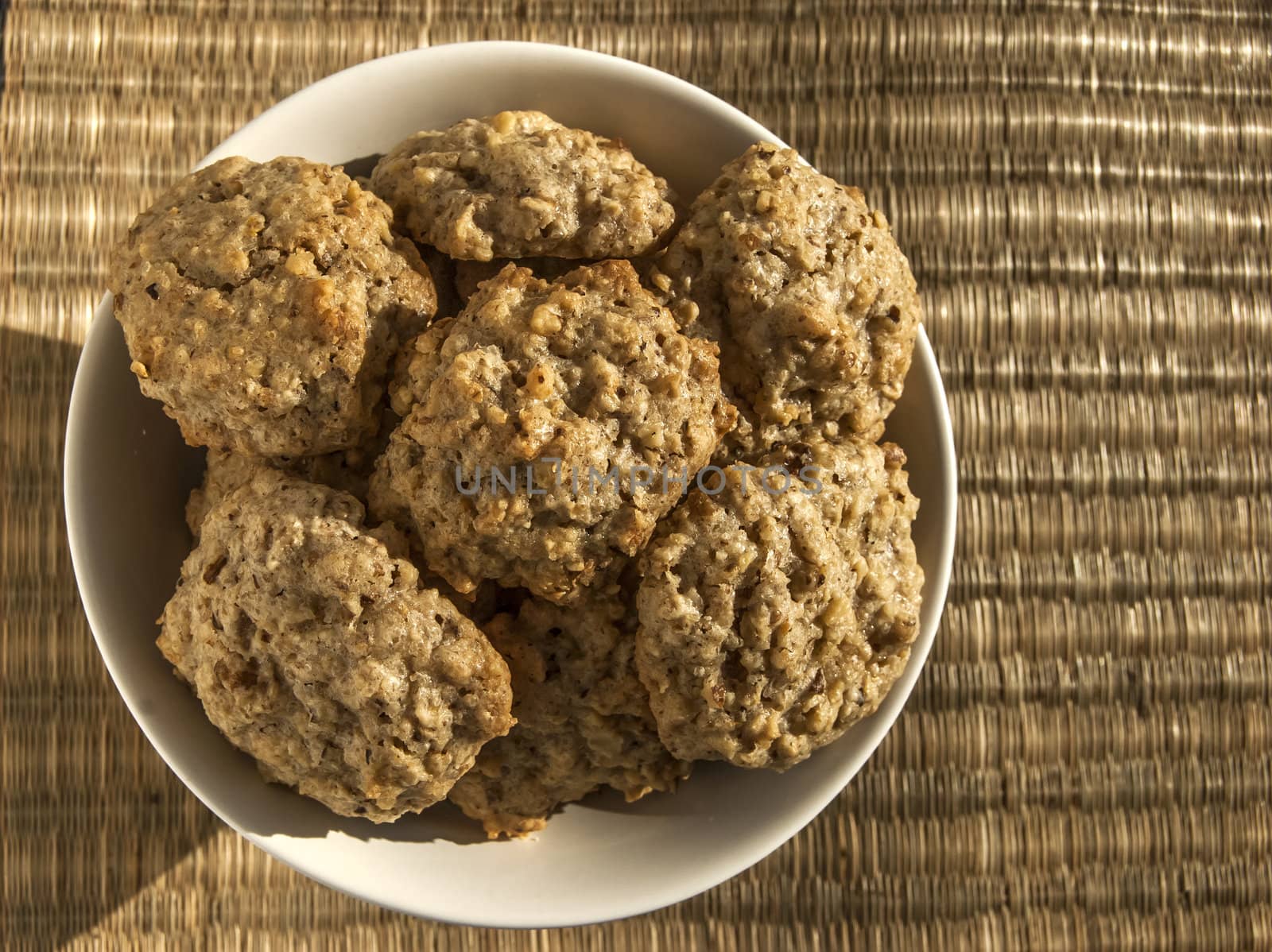 Homemade oatmeal cookies in bowl on reed mat closeup