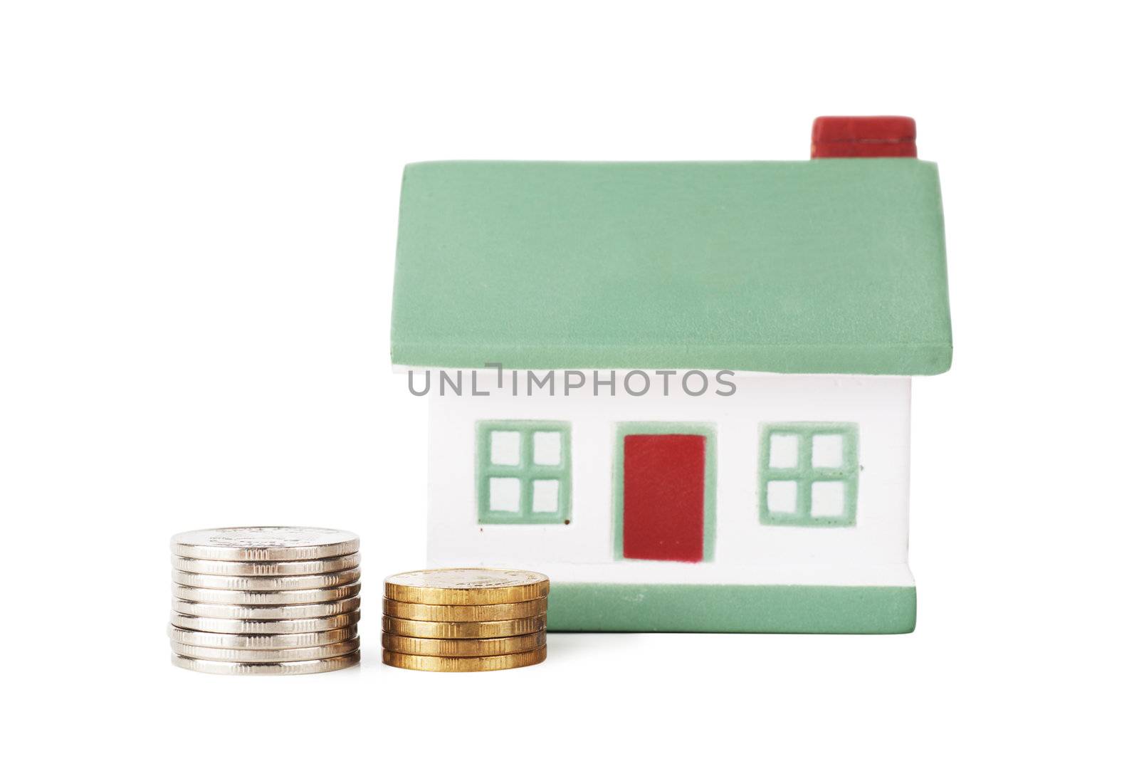 Little house toy and two stacks of coins isolated over white background