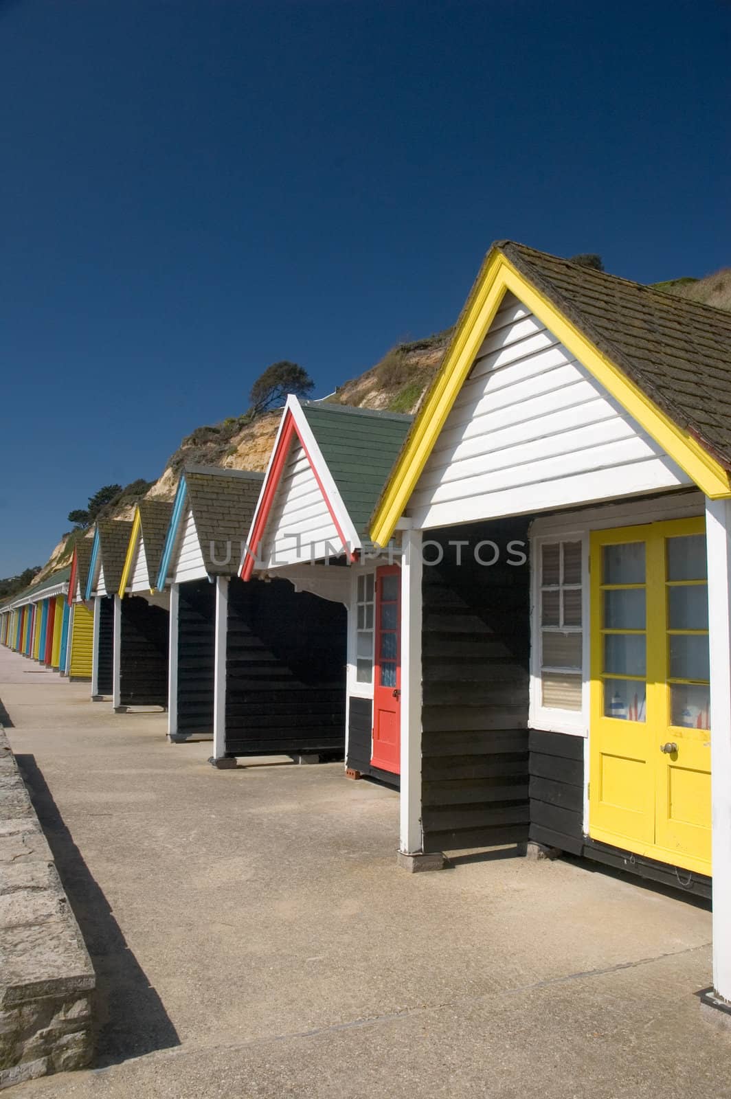 A row of colourfull beach huts on a clear sunny day