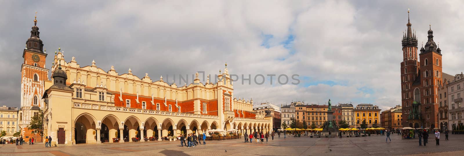 KRAKOW, POLAND - OCTOBER 11: Old market square with tourists on October 11, 2012 in Krakow. It's a principal urban space located at the center of the city and – at roughly 40,000 sq. m – it is the largest medieval town square in Europe.