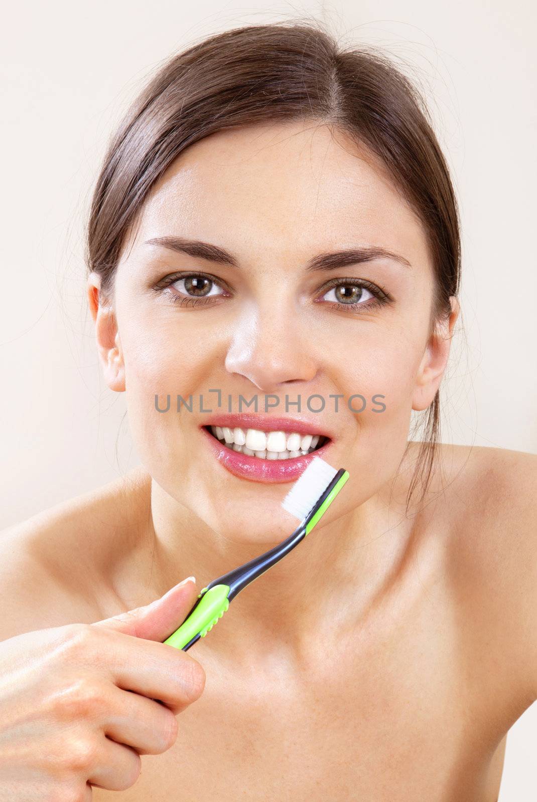 beautiful woman with tooth-brush cleans her teeth