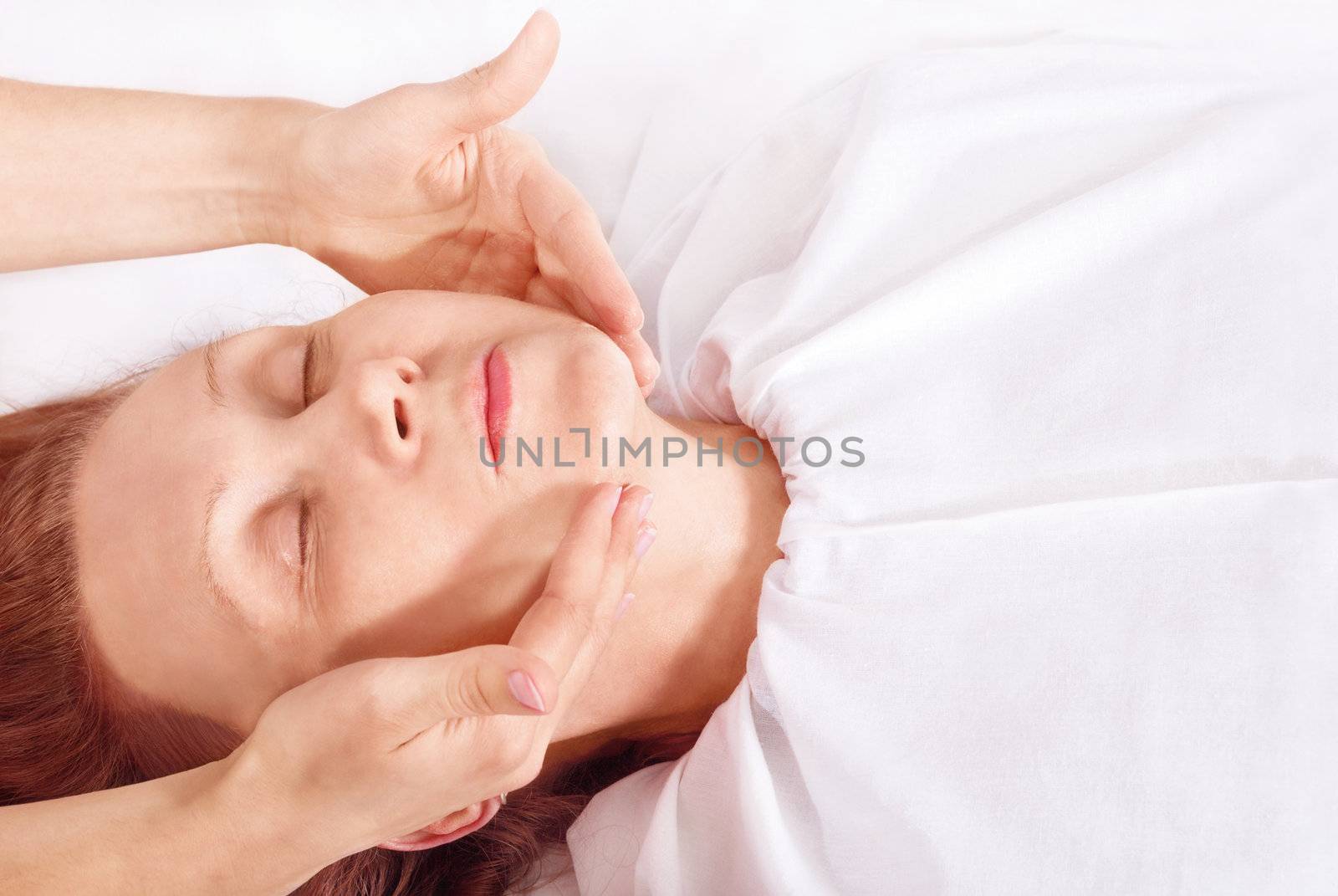 Close-up her face receiving a facial massage.