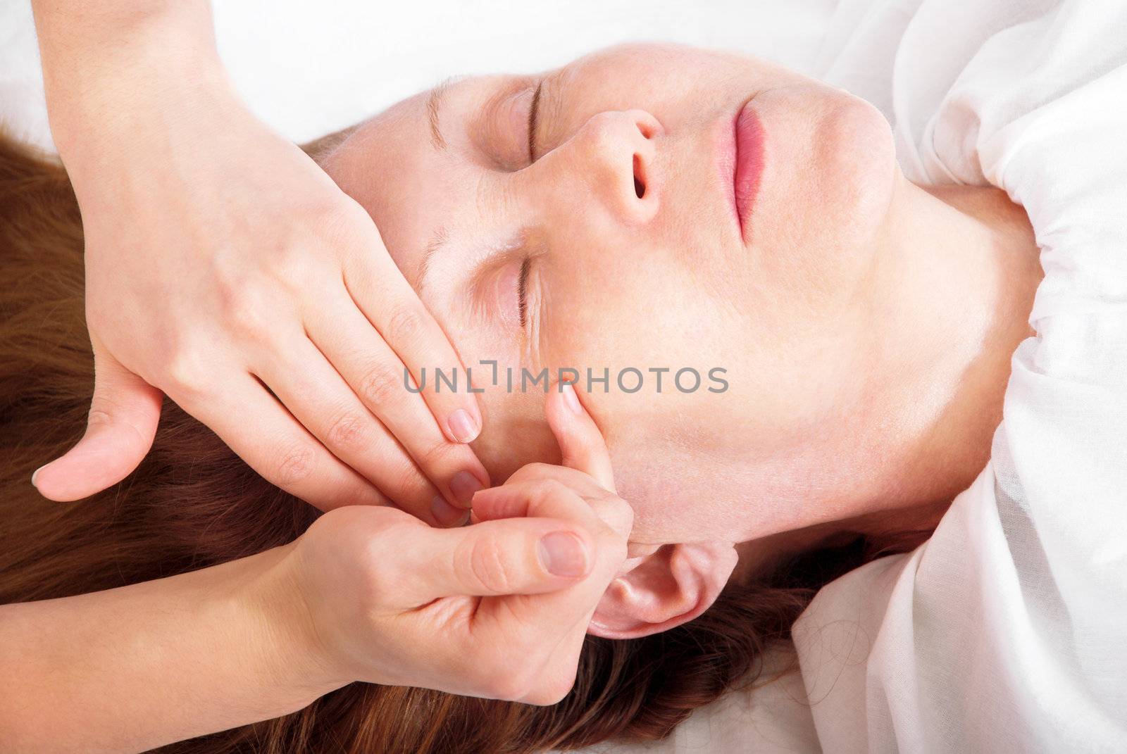 Close-up her face receiving a facial massage.