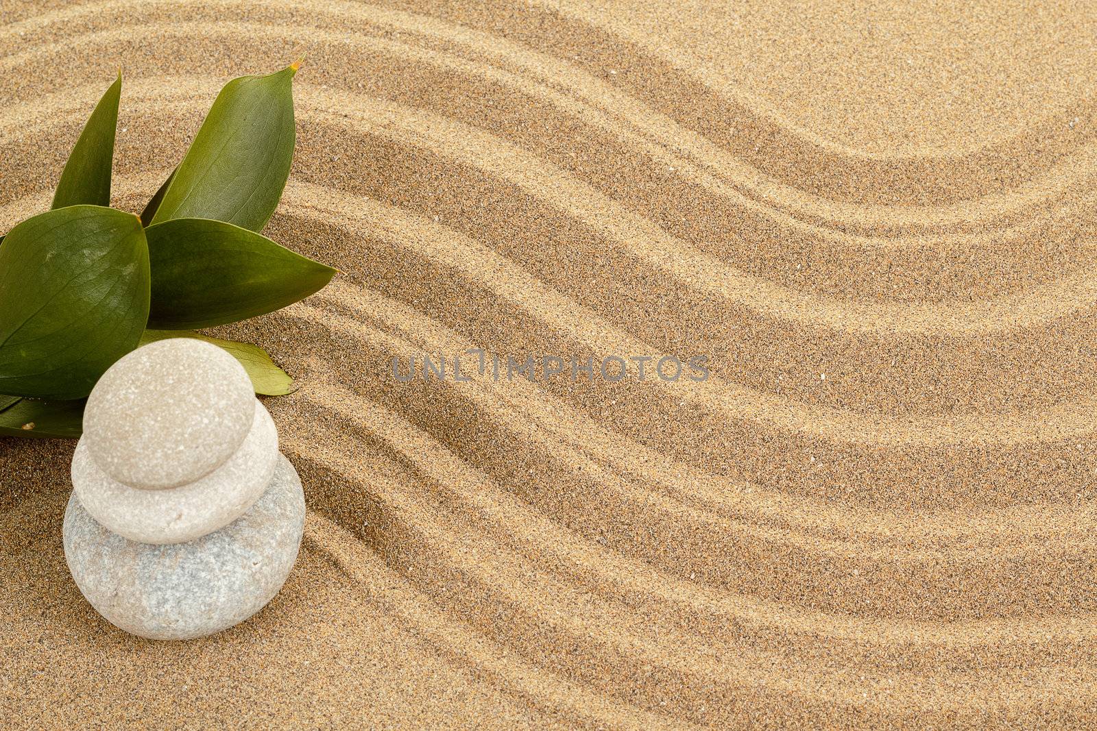 background with balance zen stones in sand and green leaves