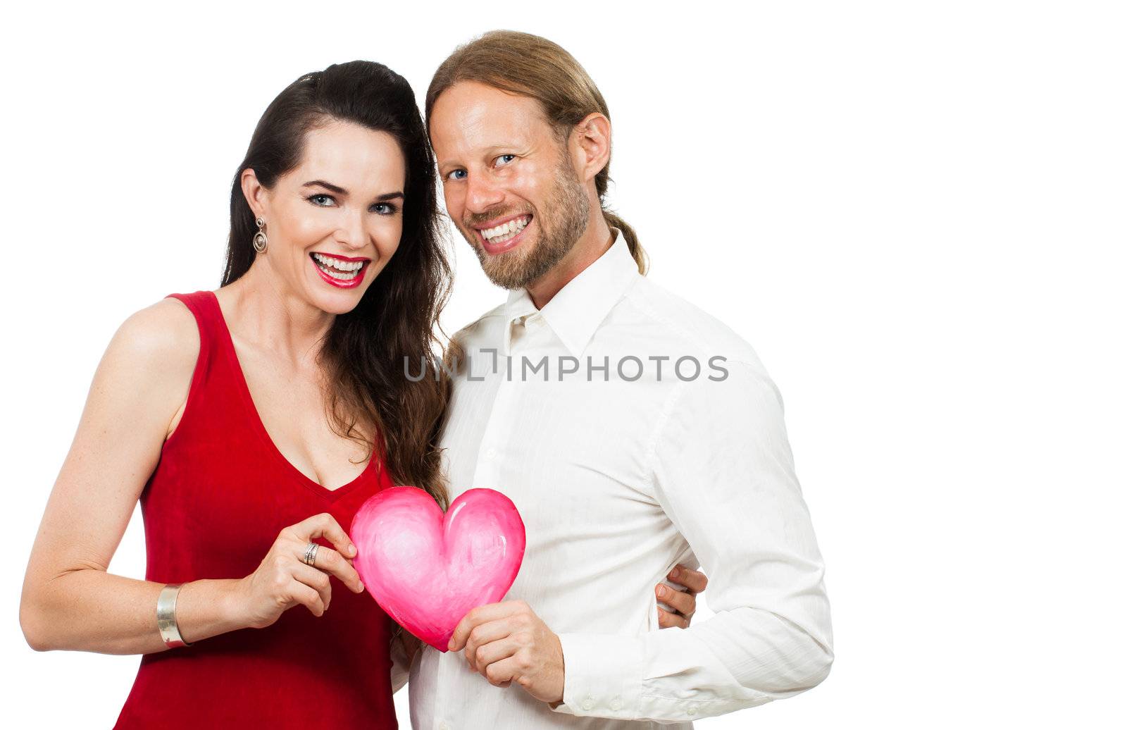 Happy beautiful couple smiling and holding a love heart. Isolated on white.