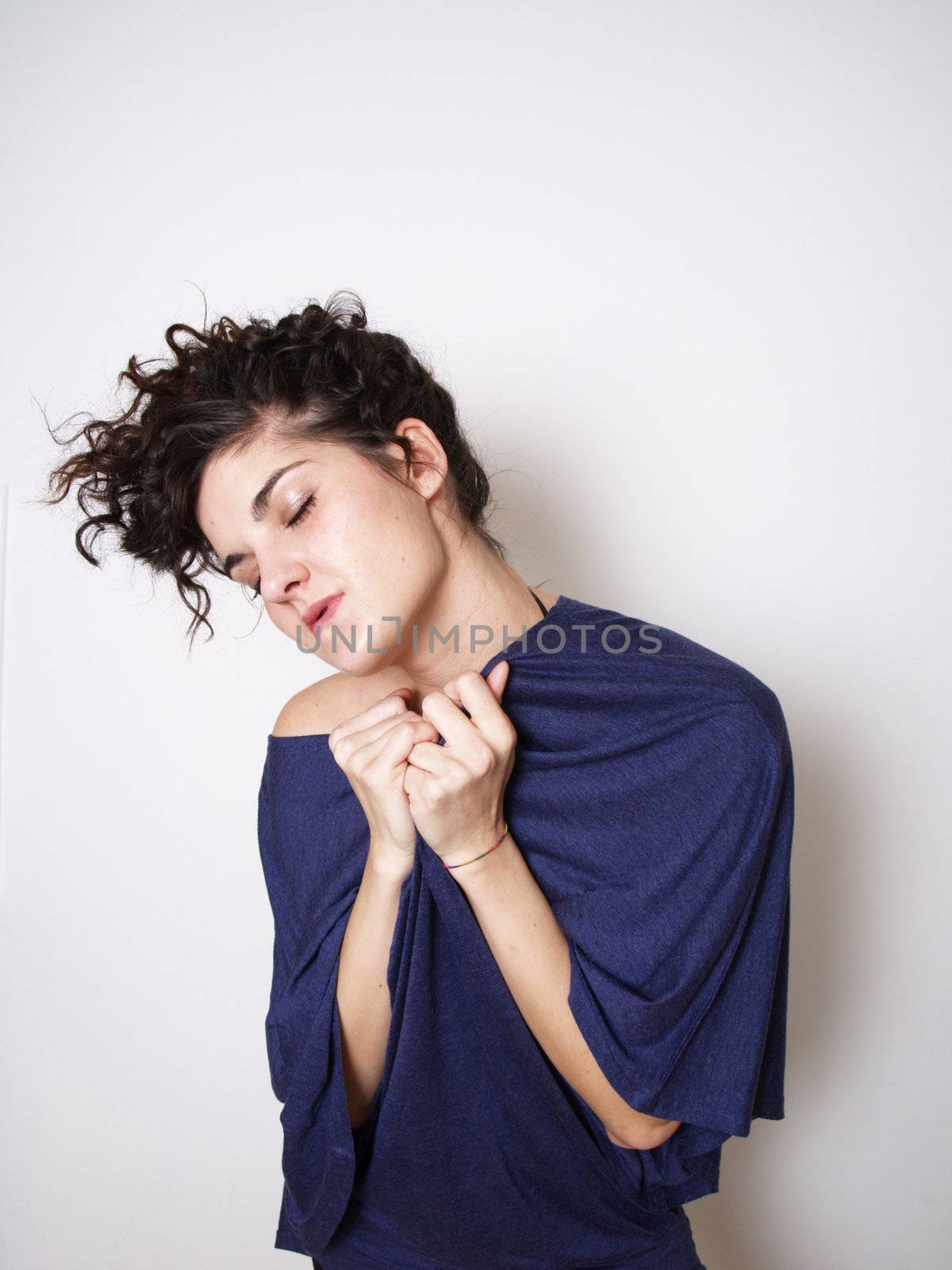 Young woman in blue t-shirt hugging herself