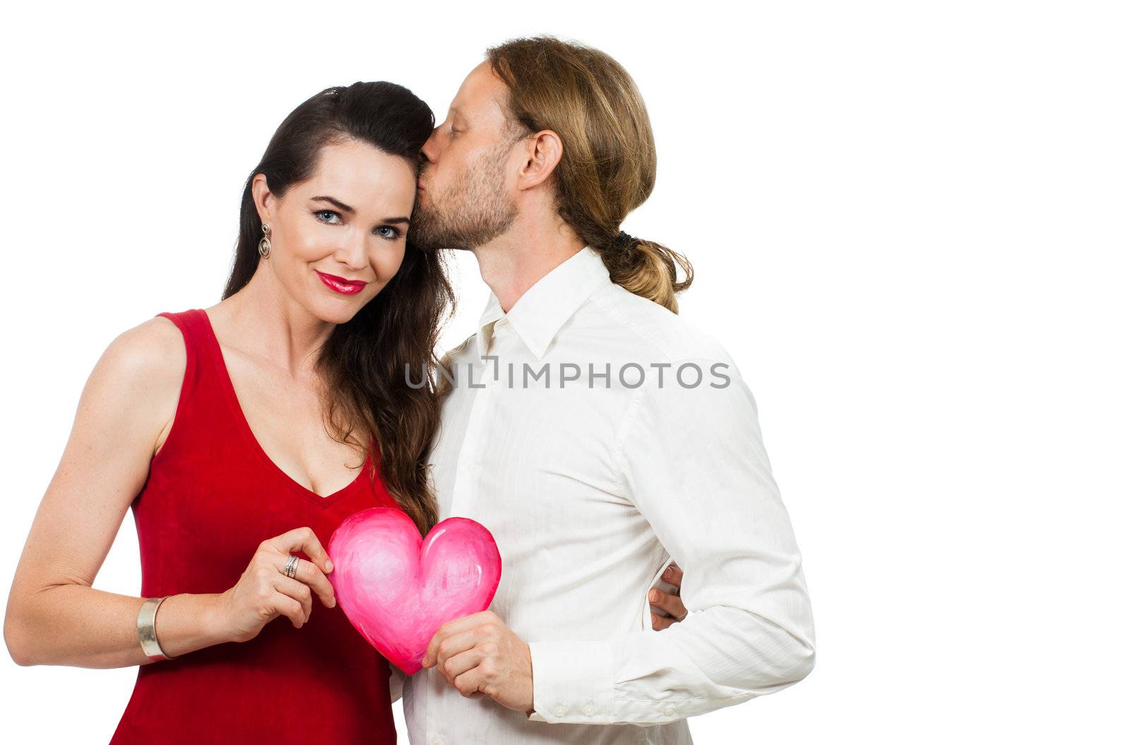 A beautiful couple in love holding a red love heart. Isolated on white.