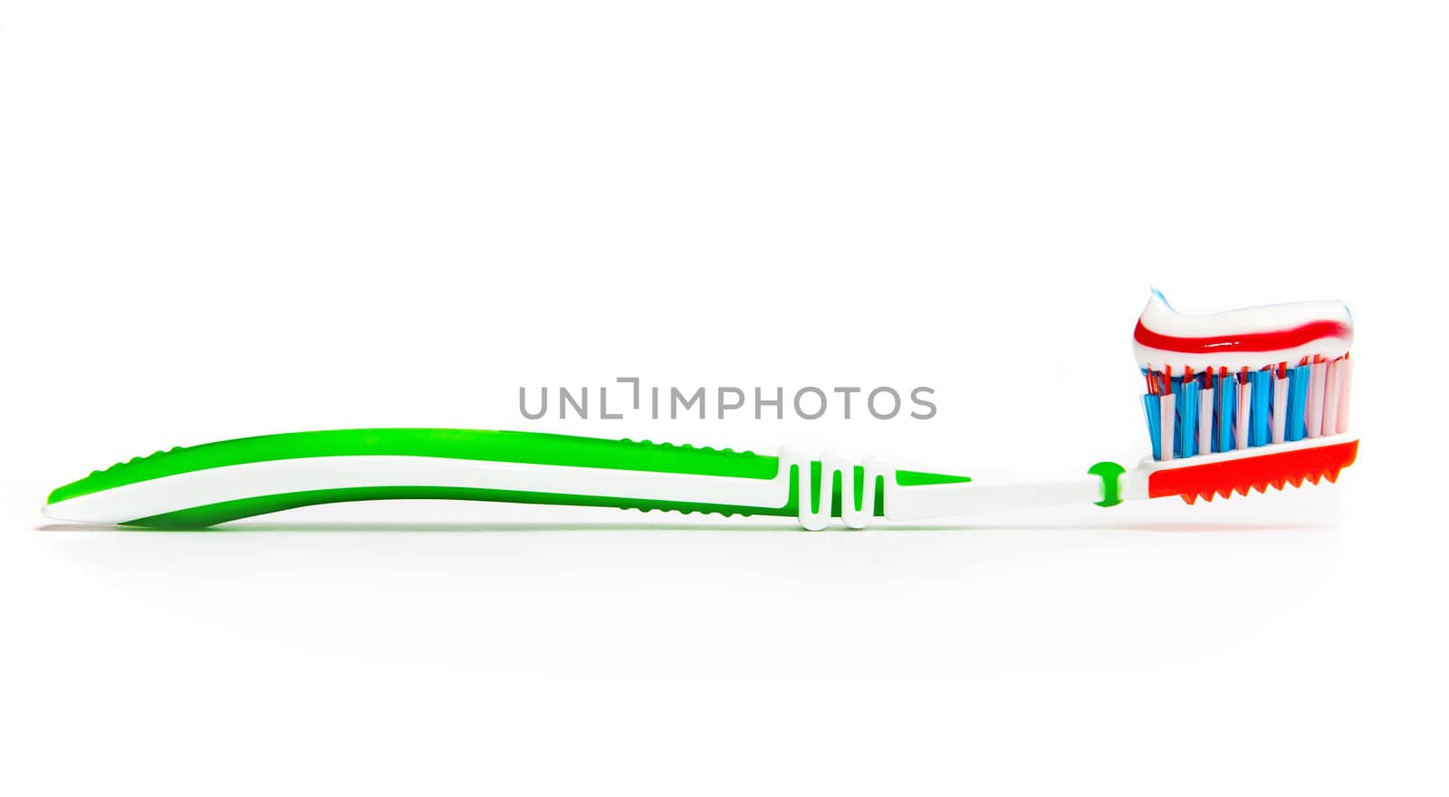 toothbrush with tricolor toothpaste on light background