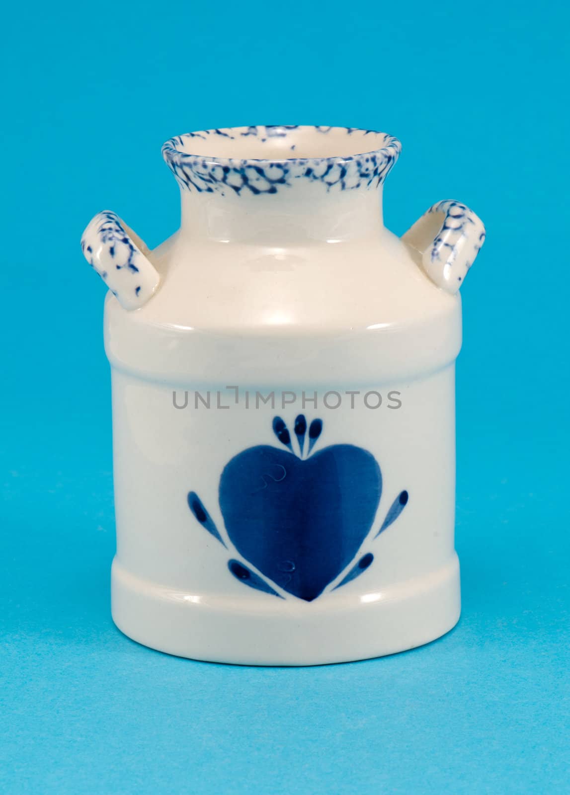 ceramic vase dish with blue heart in center on blue background.