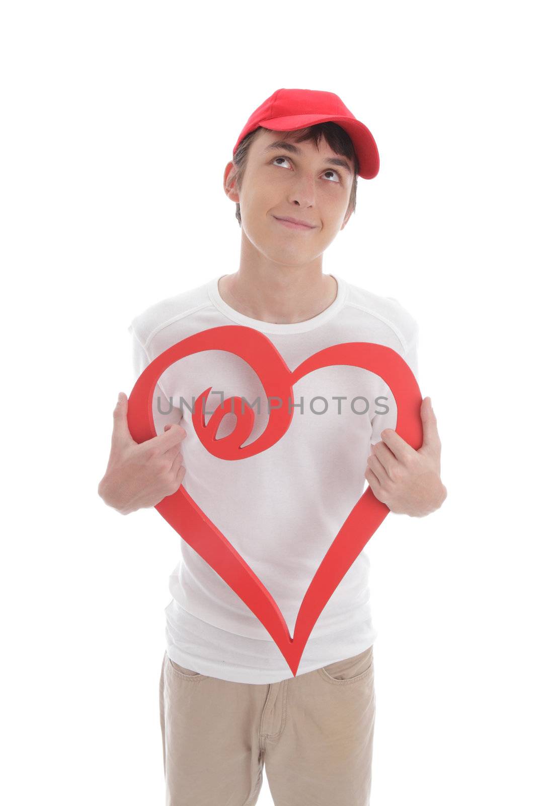 Daydreaming teenage boy holding a red valentine love heart.   Space for copy or message.