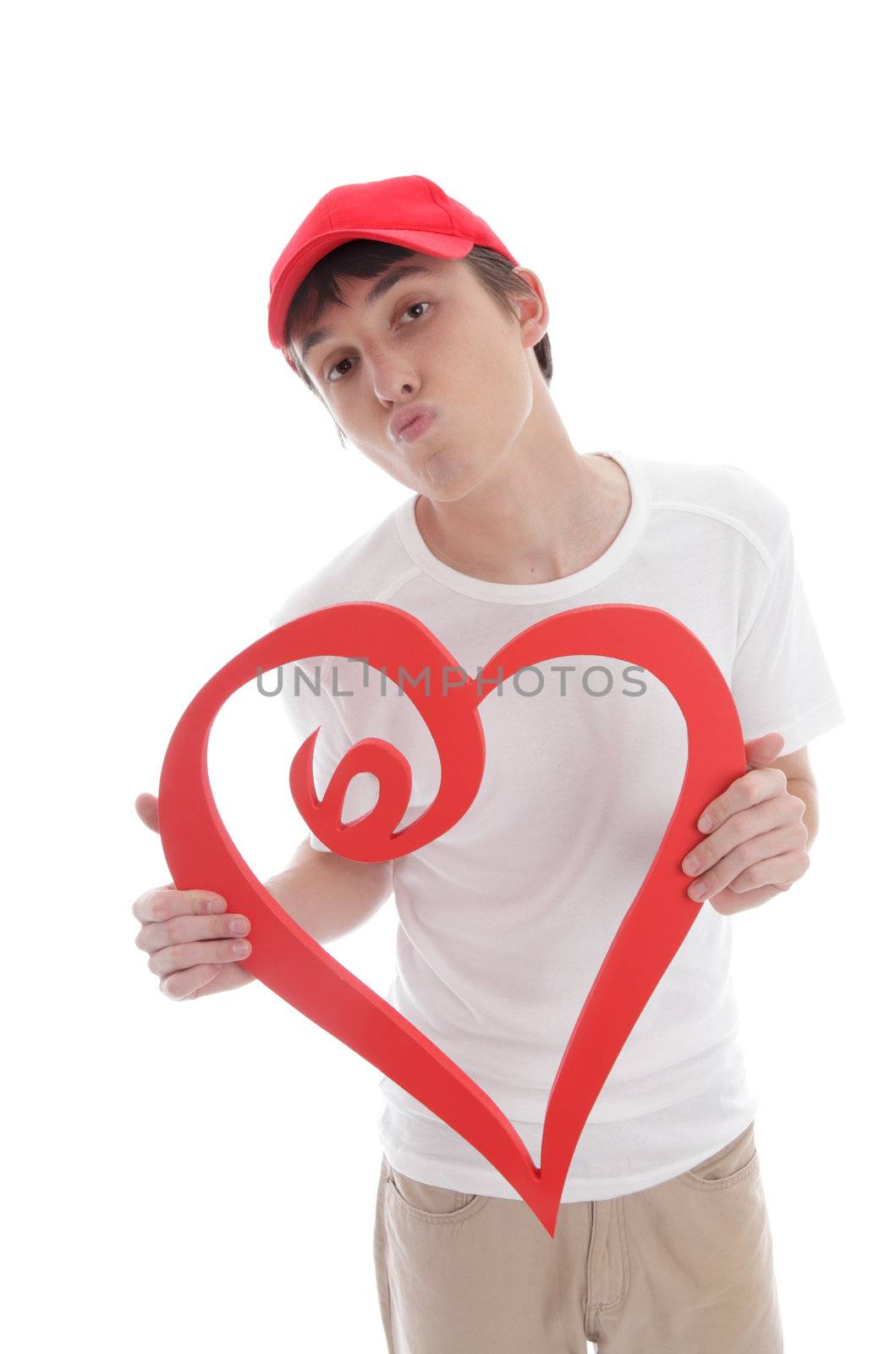 A teenage boy holding a red love heart with lips puckered up kissing.  White background.