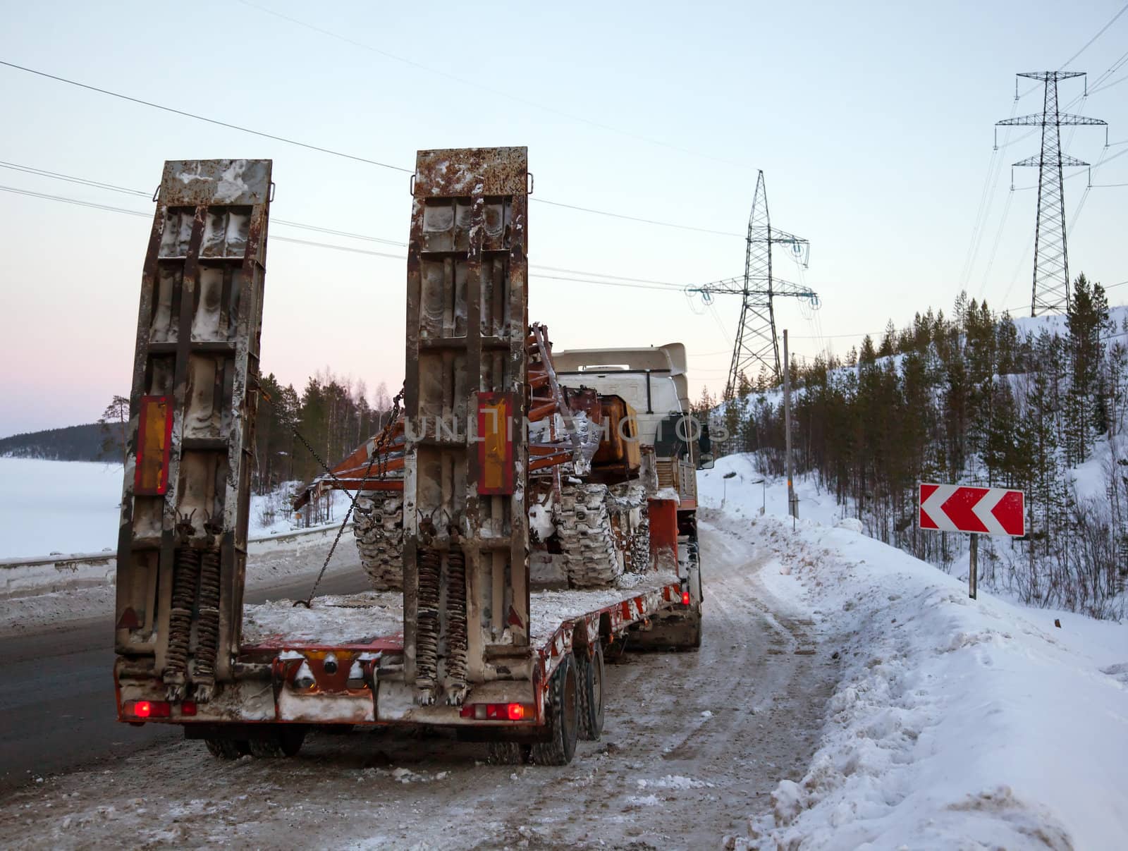Tractor-trailer transports skidder for restoration works on power lines