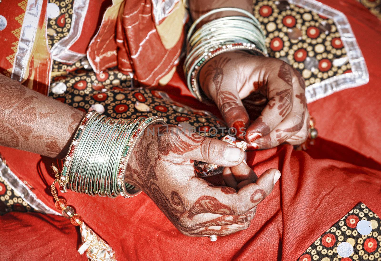 Hands of a young Indian woman adorned with traditional bangles and mehndi. Mehandi, also known as henna is a temporary form of skin decoration in India.