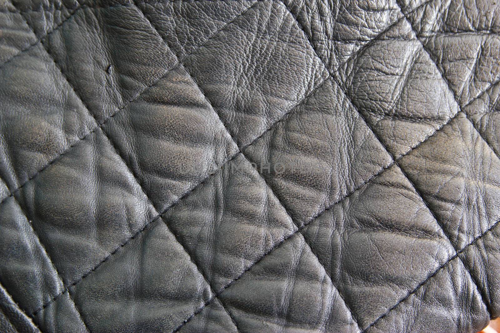 leather texture colose-up with linear stiches. Part of a leather jacket.