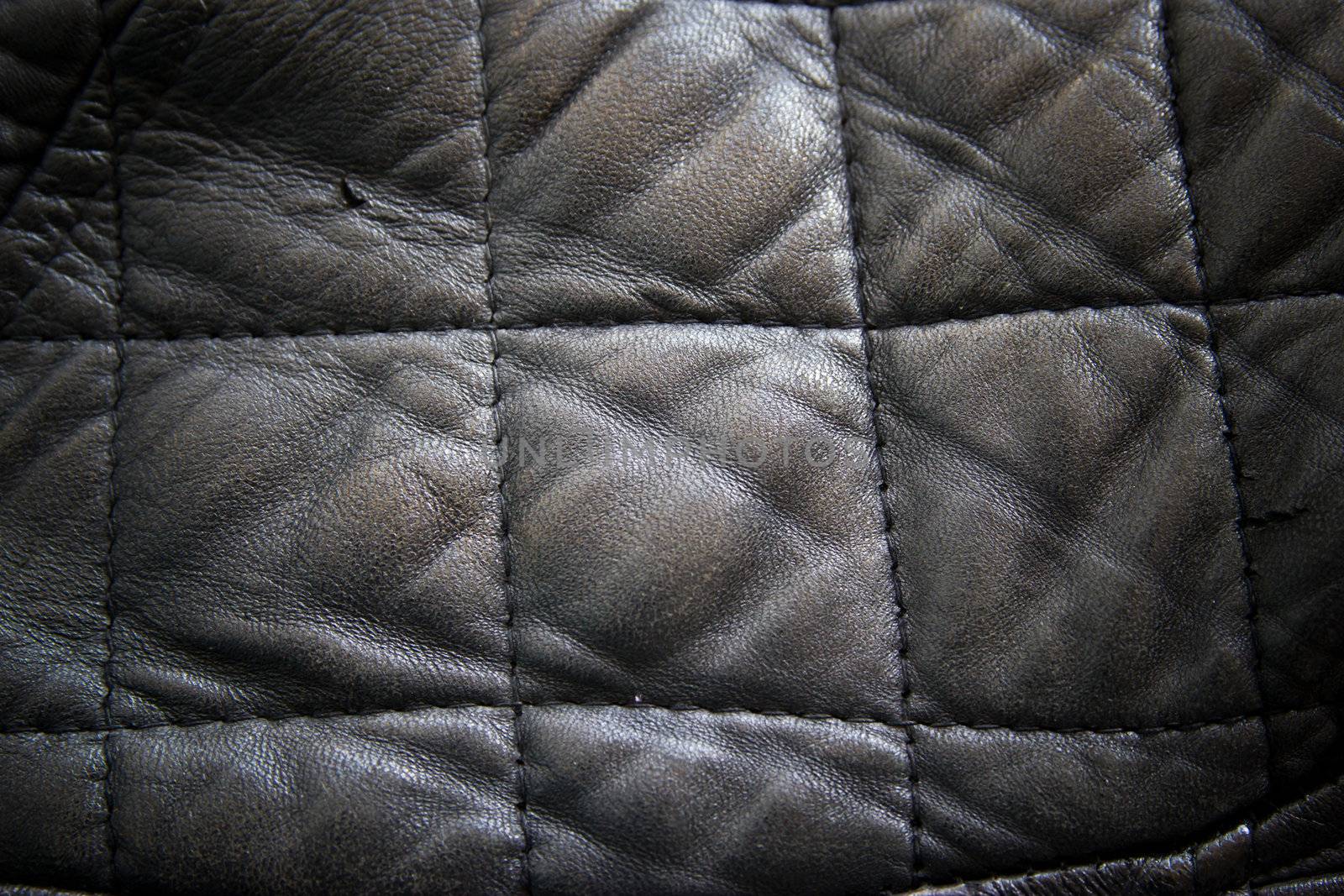 leather texture colose-up with linear stiches. Part of a leather jacket.