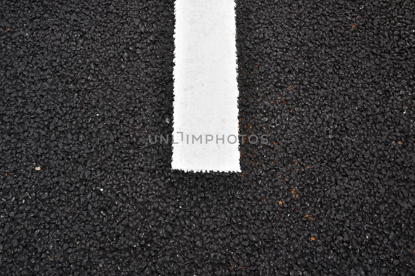 Closeup of a tar or asphalt pavement texture with a white line painted 