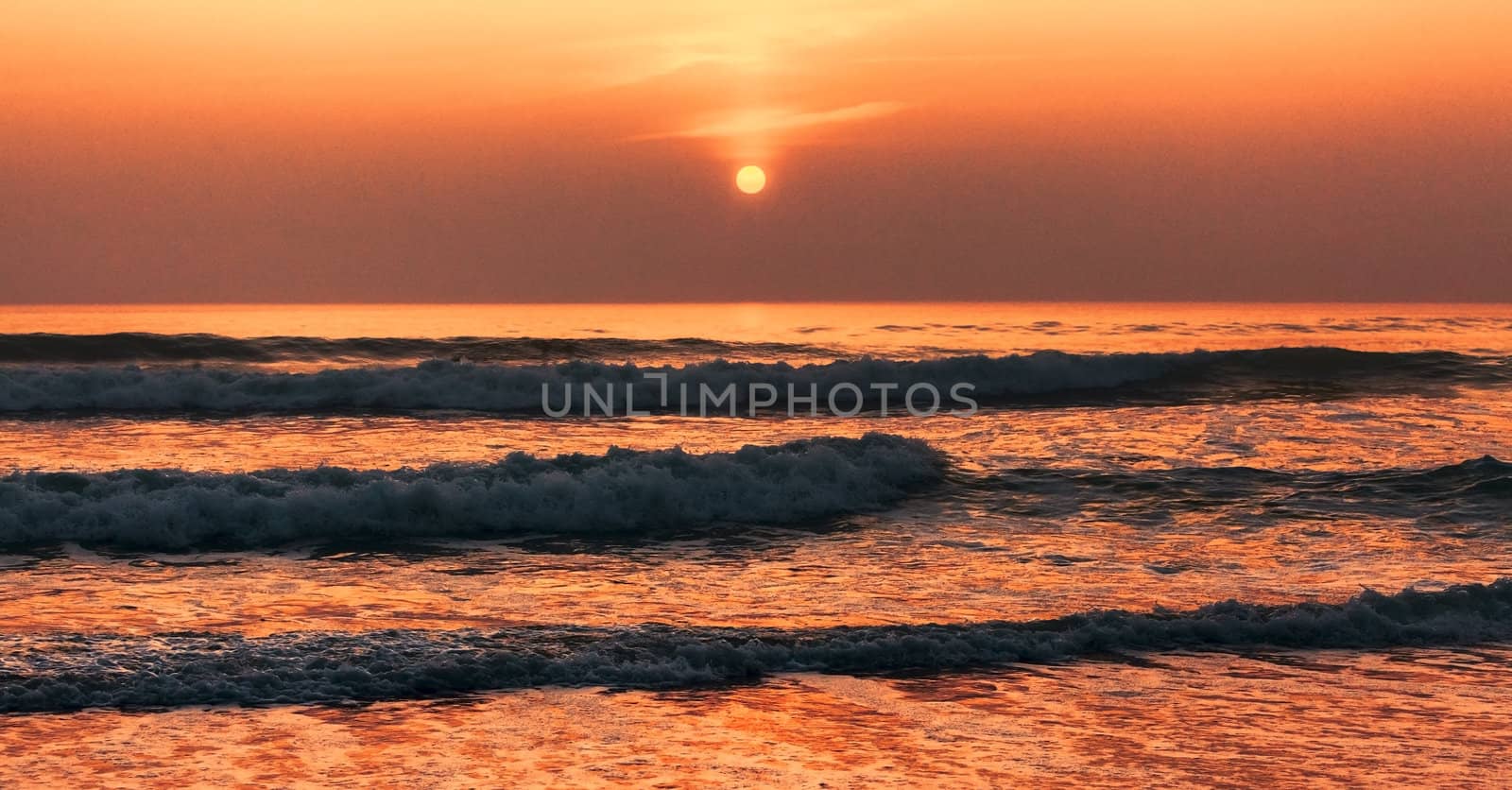 Beautiful colorful sunset over the ocean's waves.