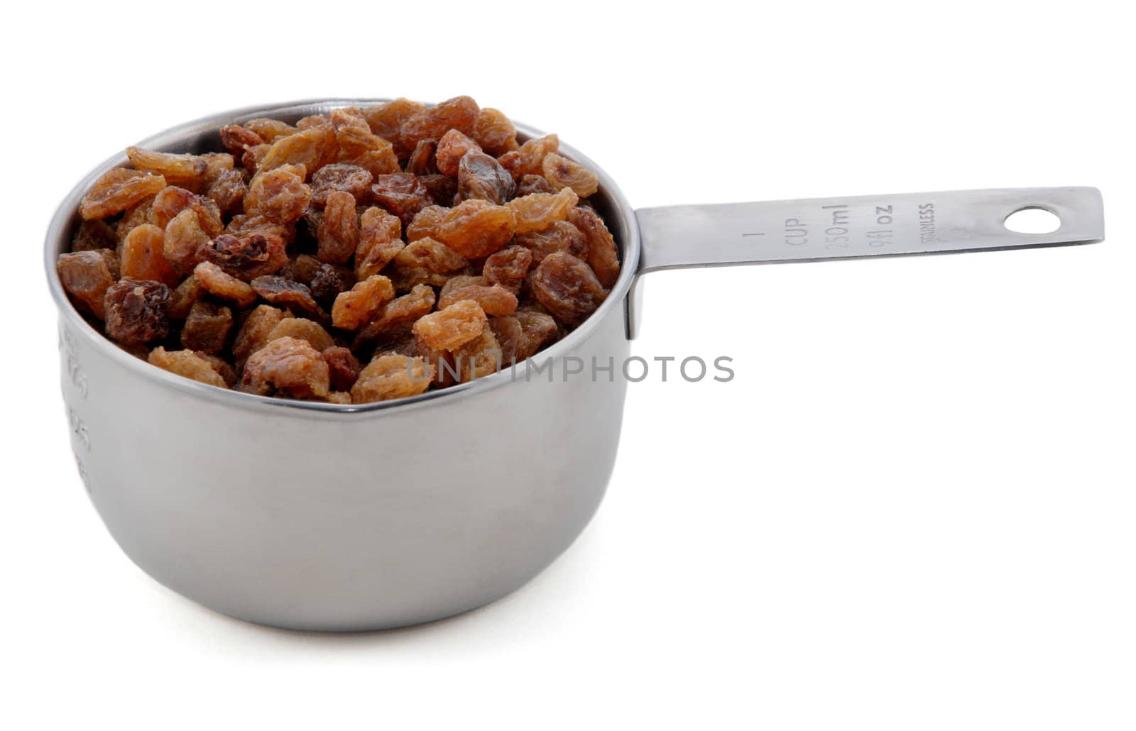 Sultanas presented in an American metal cup measure, isolated on a white background