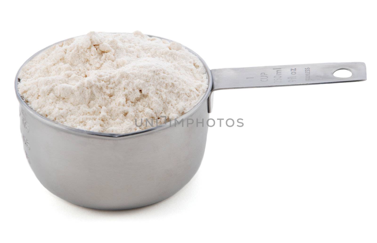 Plain / all purpose flour presented in an American metal cup measure, isolated on a white background