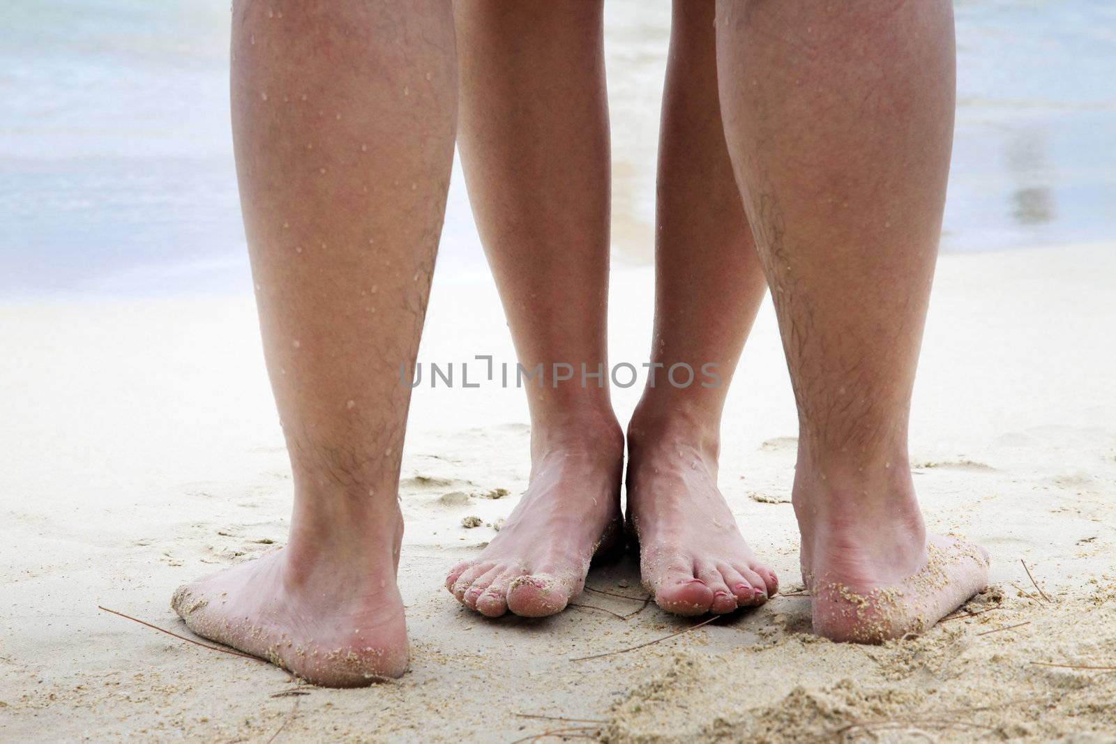Legs of couple on the sand beach
