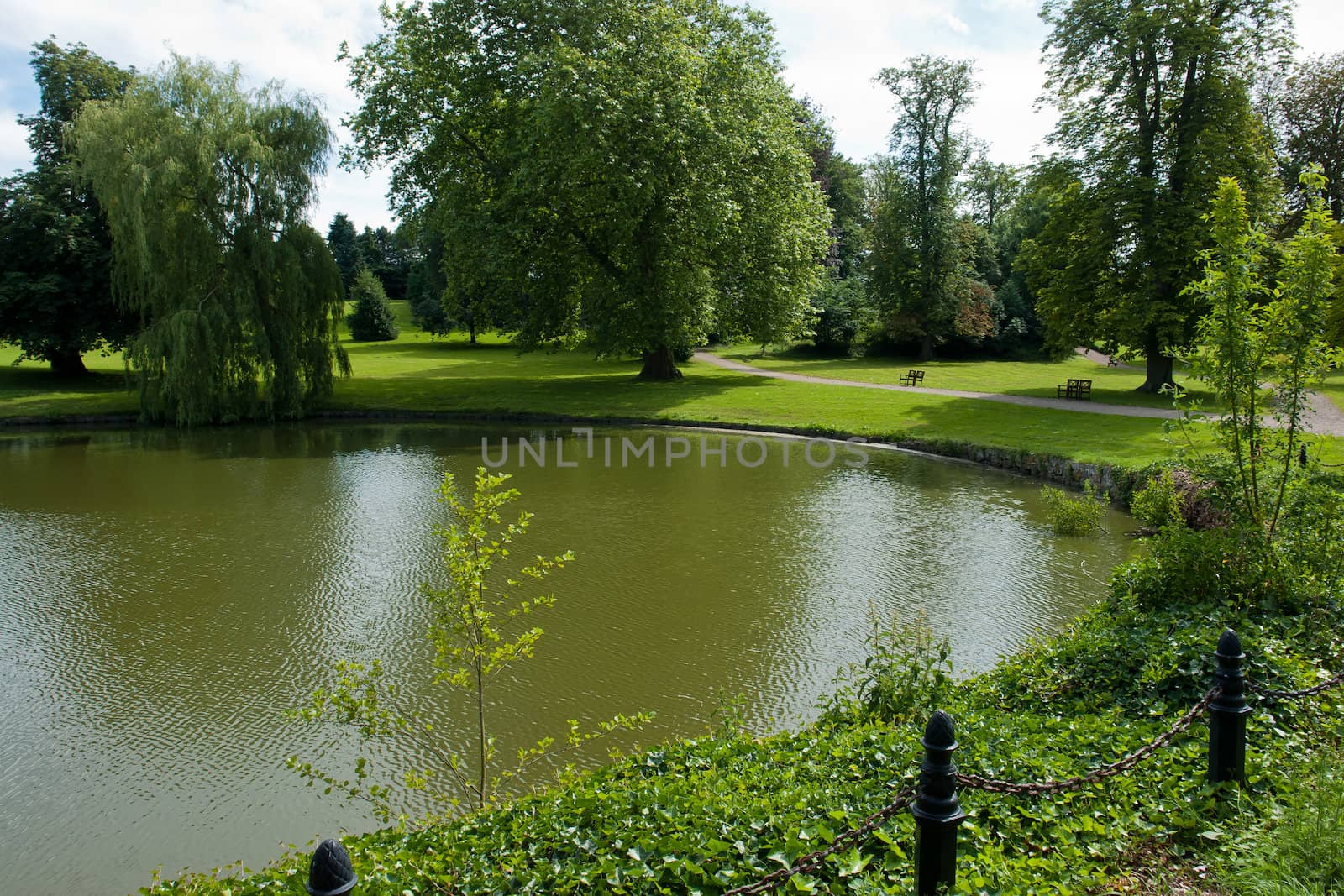 Beautifuln garden with  lawns and trees by a lake in classical mansion estate Denmark