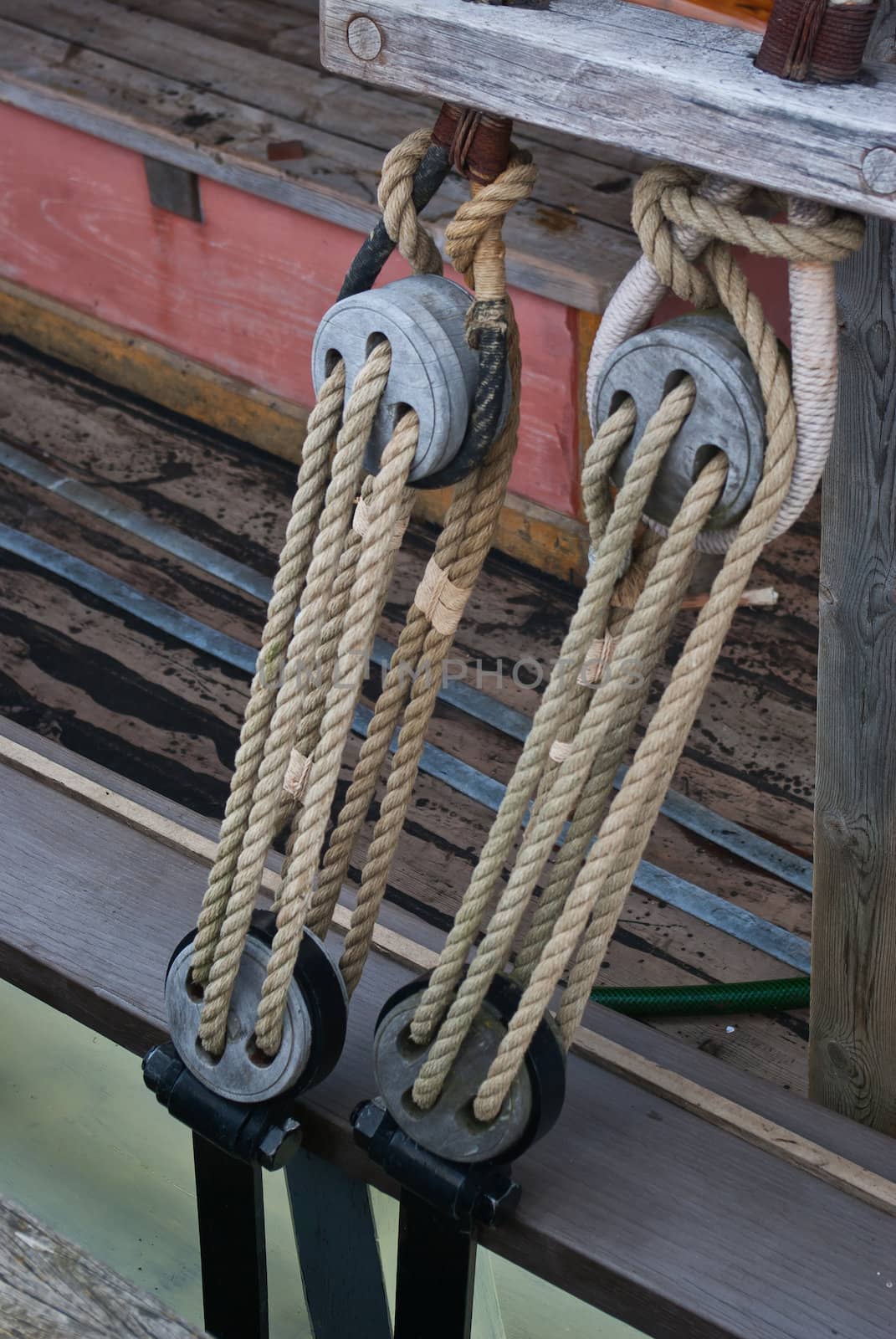 Nautical ropes and vintage wooden pulley on a sail boat sailing background image