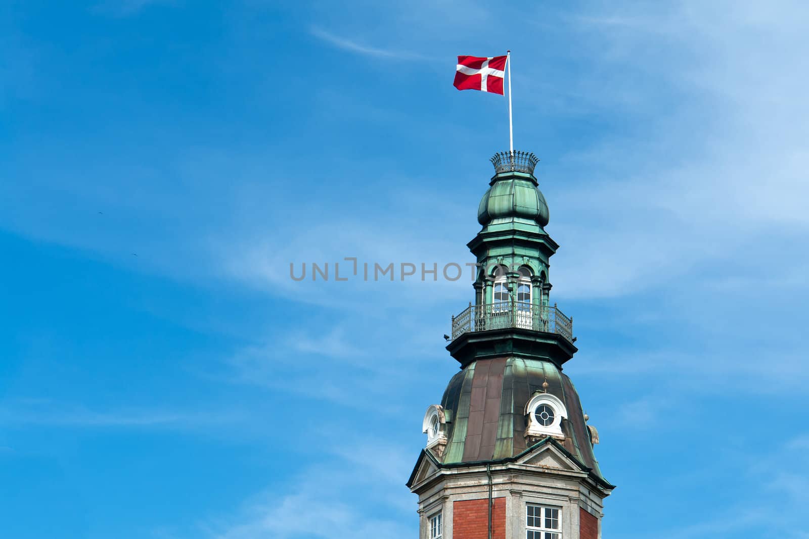 Flag of Denmark up high in the air with blue sky horizontal background